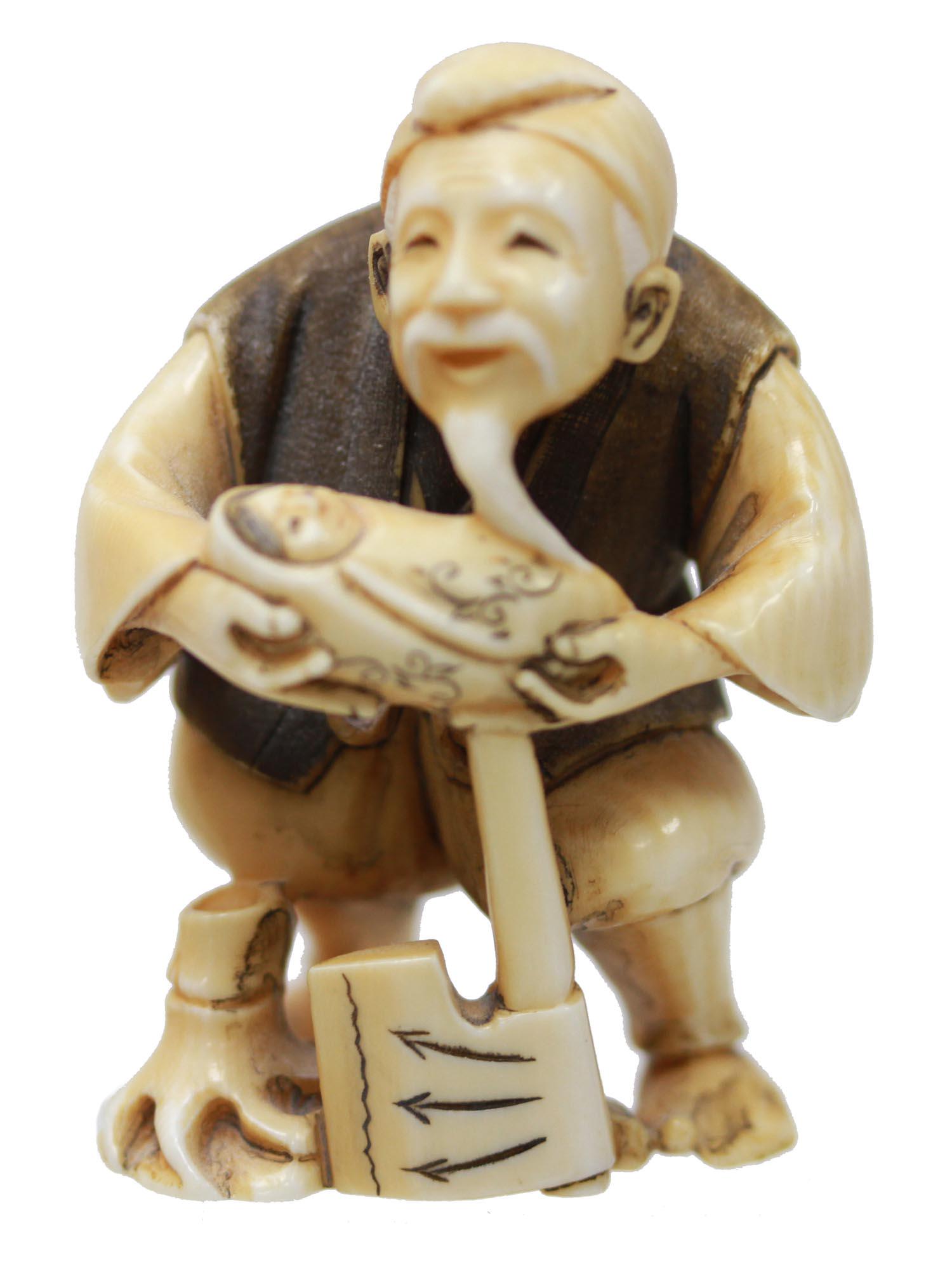ANTIQUE HAND CARVED JAPANESE NETSUKE OLD MAN BABY: An antique Japanese hand-carved, engraved, inked from natural materials netsuke, depicting an old man holding a newborn baby in his hands. There is one cord hole on the back. Marked on the bottom. Cir