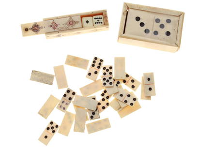 A VINTAGE CARVED MINIATURE DOMINO SET & DICE SET: A set of hand-carved miniature domino set and a dice set. A set of dice with card suits applied in black, brown, green and red pigment. Dimensions: Domino box: 2 1/4 X 1 1/2 X 1 in.Dice box: 2 1/4 X 3