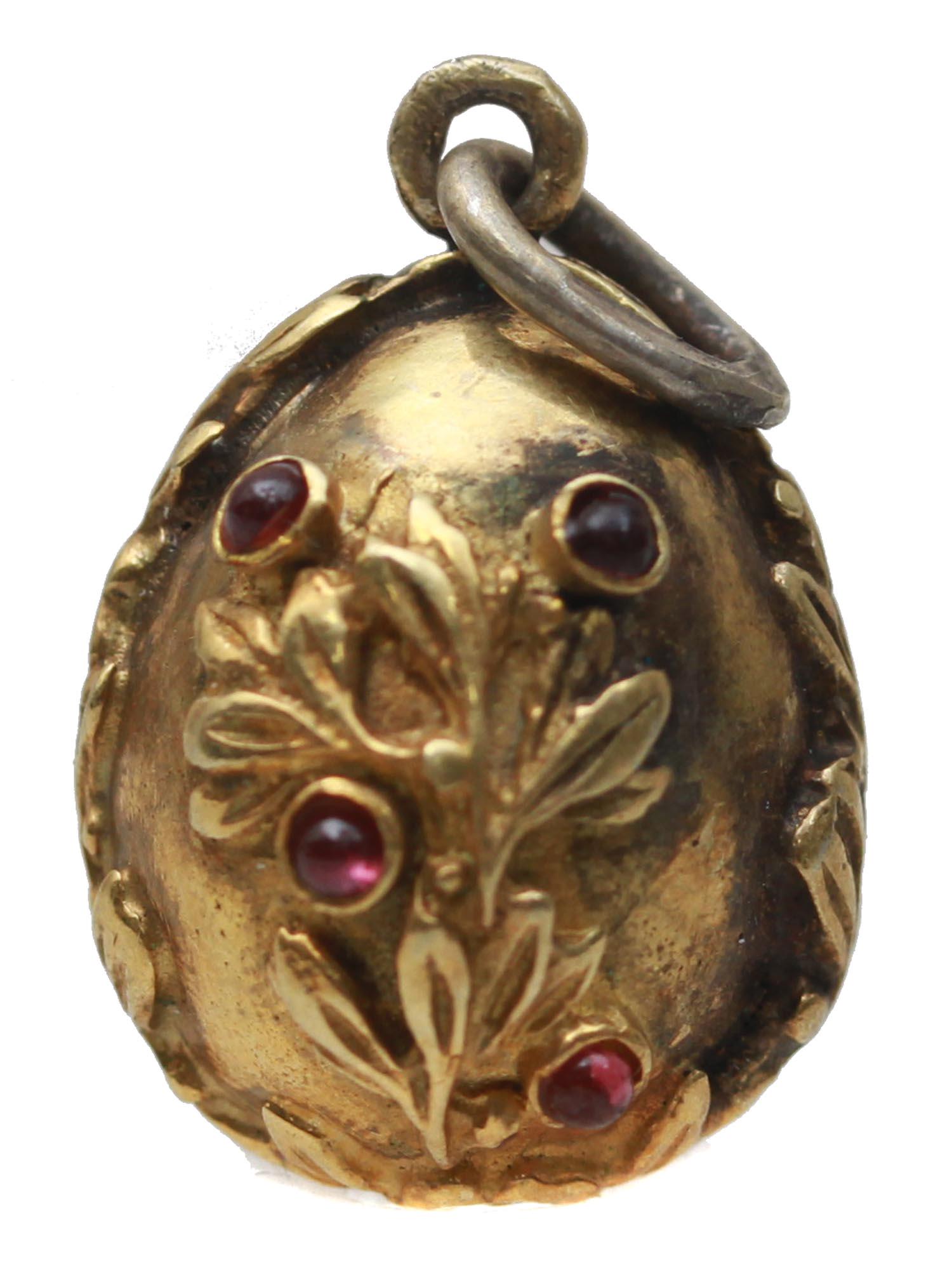 A RUSSIAN GILT SILVER EGG PENDANT WITH STONES: A Russian gilt-silver Easter Egg pendant The exterior is adorned with relief flowers and leaves patterns and inlaid with burgundy semi-precious stones. Marked with Russian hallmarks, Silver standard m