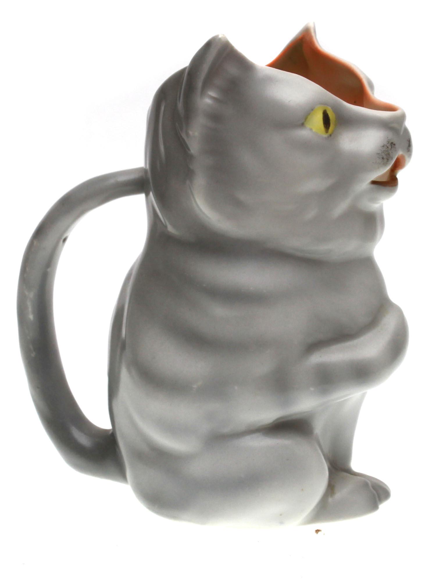 A VINTAGE ROYAL BAYREUTH PORCELAIN CAT CREAMER: A vintage Bavarian Royal Bayreuth porcelain creamer in the form of a cat figurine in grey color. Decorated with a tail form handle. Marked in blue, Royal Bayreuth Bavaria, on the bottom. Circa: the ea