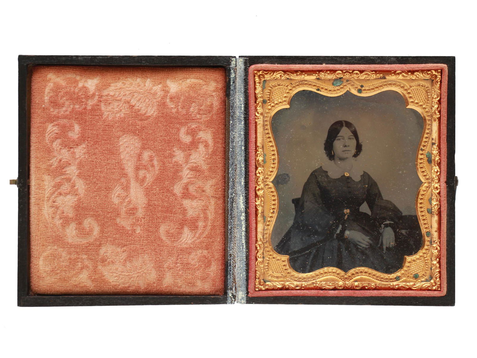 AN ANTIQUE AMERICAN TINTYPE PHOTOGRAPH PORTRAIT: An original 19th-century American tintype portrait of a lady in an original thermoplastic case with a brass fastener and red velvet linen. Dimensions: 3 1/2 X 3 in.