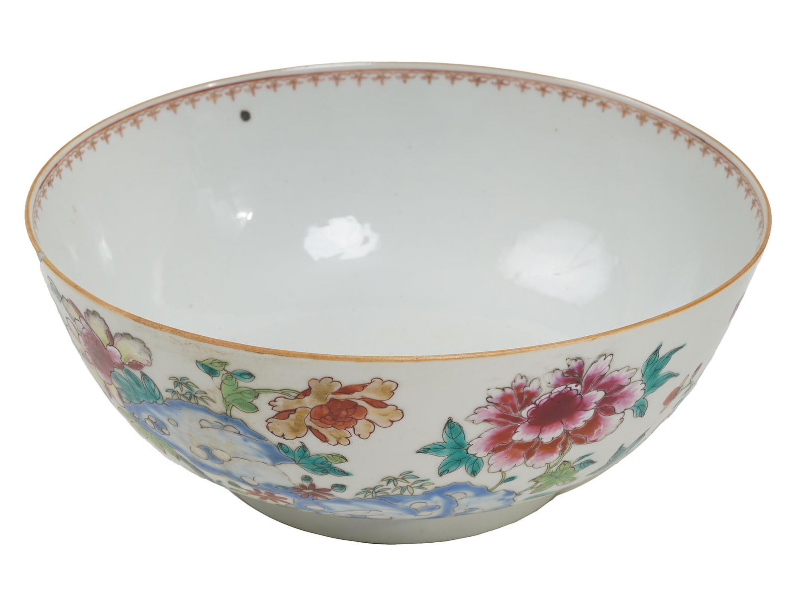 AN ANTIQUE CHINESE FAMILLE ROSE PUNCH BOWL: An antique Chinese porcelain bowl decorated with a beautifully hand painted Famille Rose garden scene and an inner rim border pattern. There is a flower in the middle of the base of the bowl. Unmarked