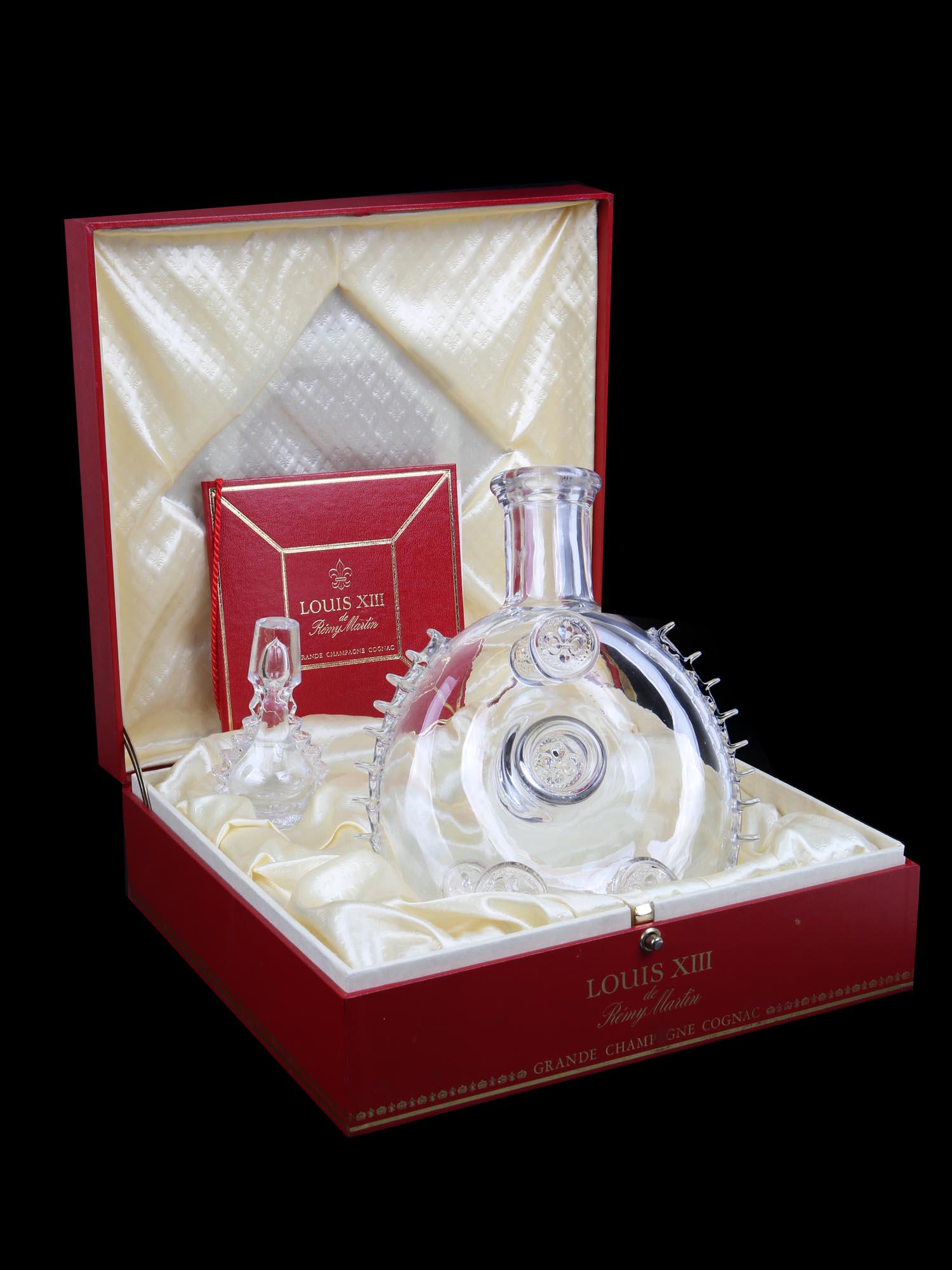 A LOUIS XIII REMY MARTIN COGNAC BACCARAT DECANTER: An original iconic Baccarat crystal decanter made for Remy Martin Louis XIII Grande Champagne Cognac. This beautiful piece of blown glass is adorned with fantastic artistry, details, and the Fleur-de-