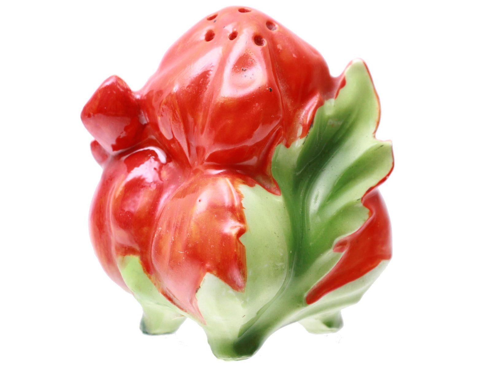 A PORCELAIN TOMATO SHAPED SALT SHAKER: A porcelain salt shaker in the form of tomato with leaves in red and green shades. Marked in blue ink on the bottom. The auction paper labels with a number on the bottom. Dimensions: H: 2 3/4 in.