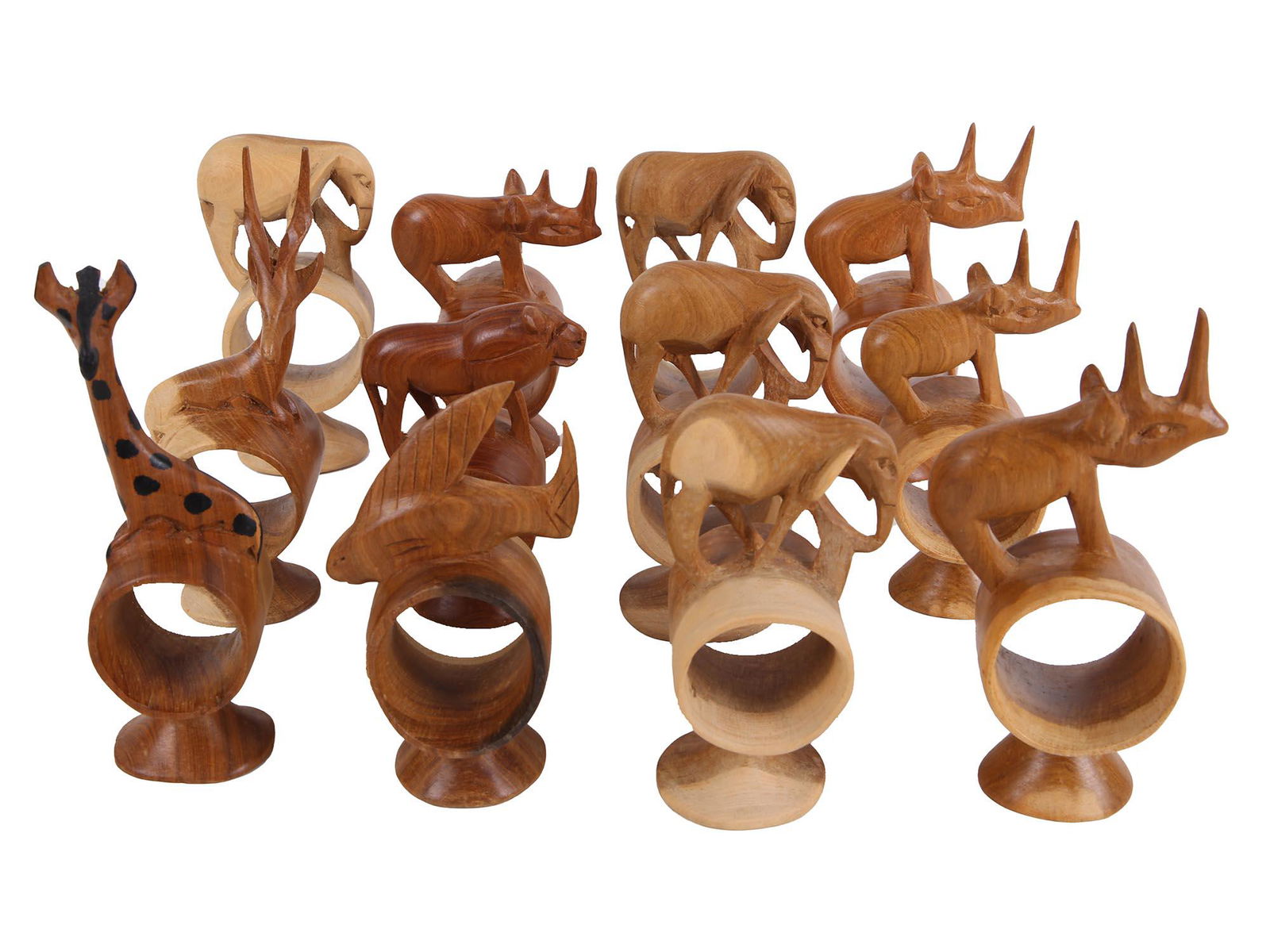 TWELVE HANDMADE CARVED WOOD ANIMAL NAPKIN HOLDERS: A lot of twelve handmade hand carved from wood napkin holders. the napkin holders are made in the shape of various animals, giraffe, elephants, lions, fish, rhinos. Presented in a cardboard box. Dimen