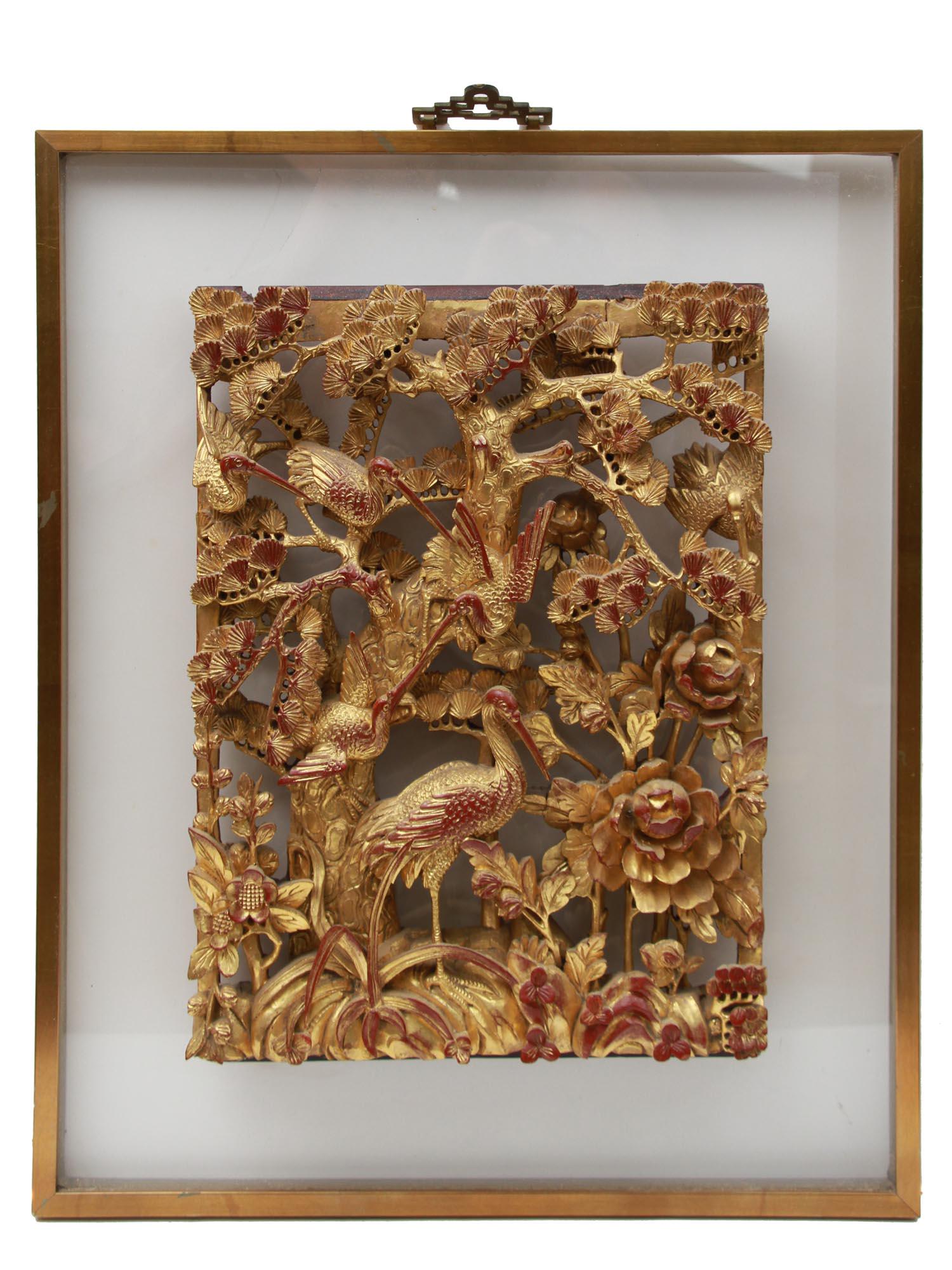 A CHINESE HAND CARVED & GILDED CRANES WOOD PLAQUE: A Chinese artfully hand-carved and gilded wooden plaque depicting cranes among the intertwined foliage of trees. Framed. The original label of the Yuen Kee brand on the back. Dimensions: Frame size: 2