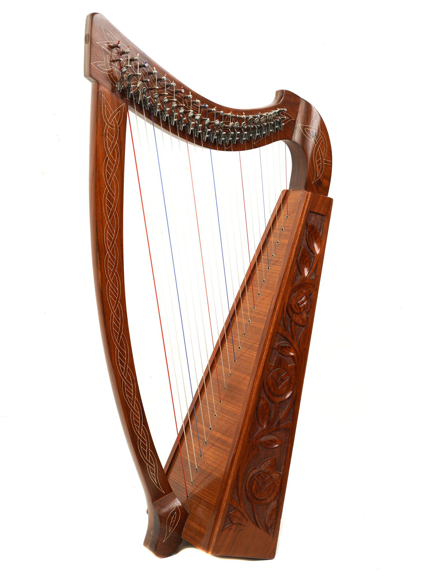 HAND CARVED WOOD STRINGED MUSICAL INSTRUMENT HARP: A vintage stringed plucked Folk musical instrument wooden harp. The harp is hand-carved in Celtic design and adorned with metal inlays. Circa: early 20th century. Folk musical instruments and harps co