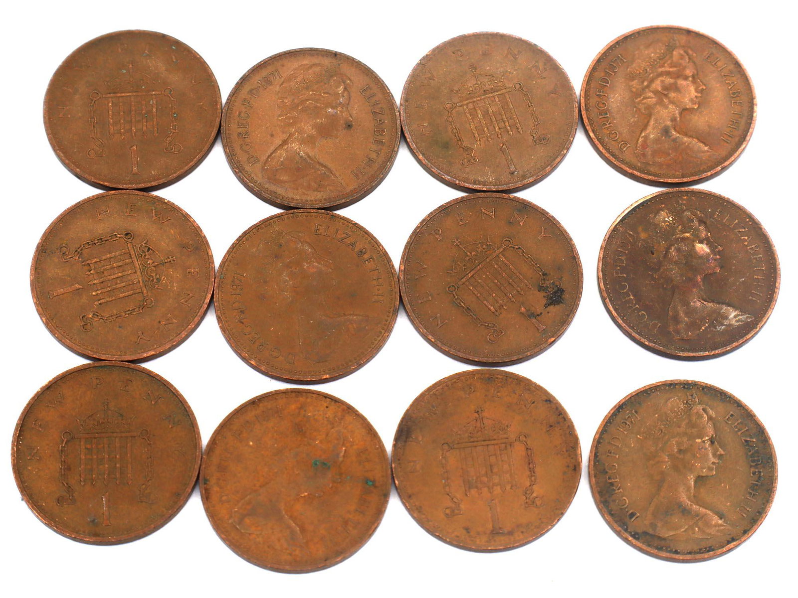 UK ONE NEW PENNY BRONZE COINS ELIZABETH II 1971: Lot of twelve bronze Queen Elizabeth II one new penny coins. The United Kingdom 1 penny coin was one of three new coins introduced into general circulation on 15 February 1971 when the United Kingdom