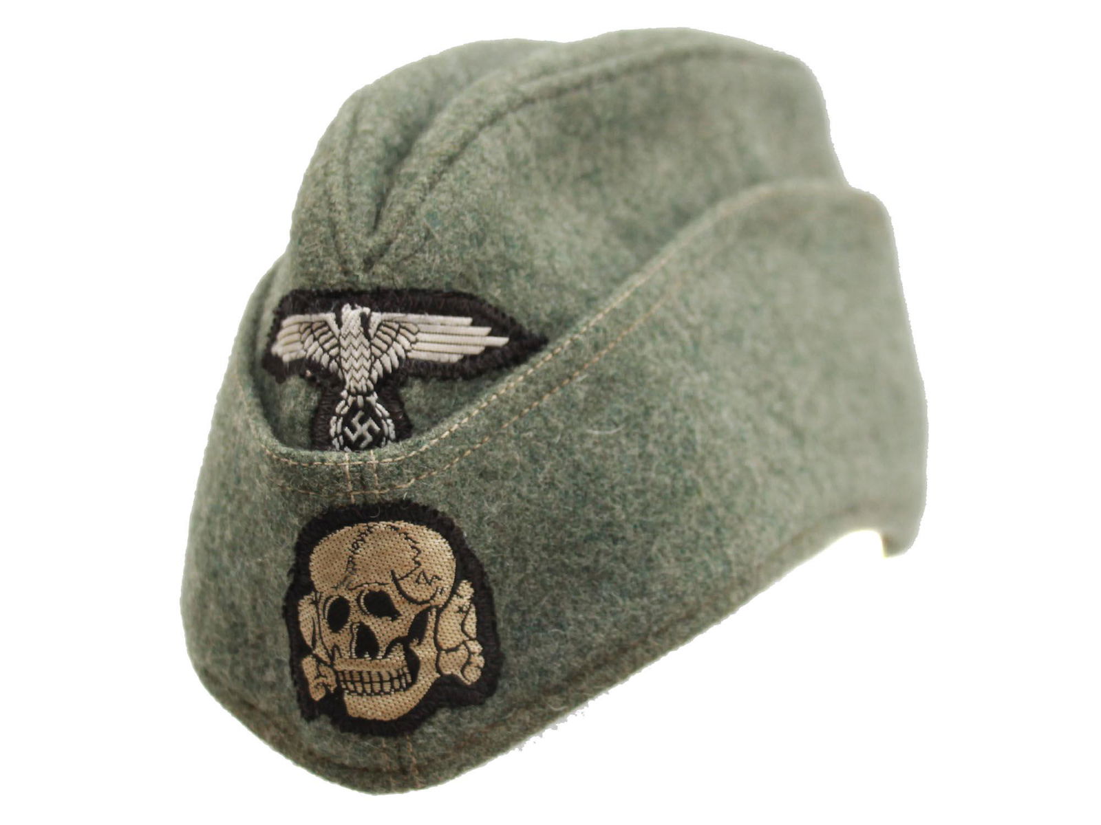A WW2 NAZI GERMAN SIDE CAP: An original German SS M40 Side Cap with a machine-applied SS cap eagle and skull on the front. Beige lining hand-signed on the inside: Pearse S. / Meighan / 122's South Main st / Waupaca WI 54981 / AP