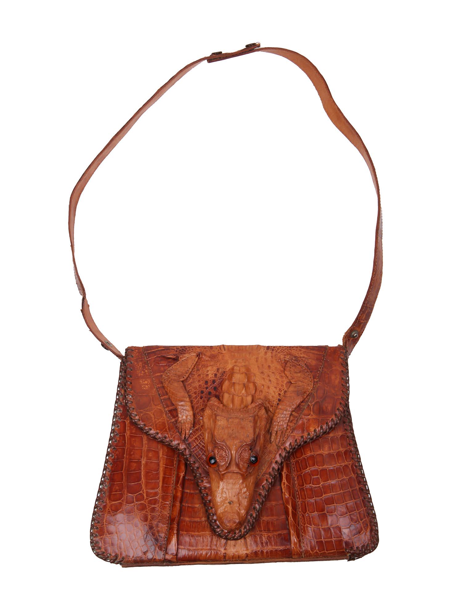 VINTAGE FIGURAL ALLIGATOR CLUTCH BAG HANDMADE CUBA: A vintage medium size figural alligator bag made in Cuba with glass eyes, paws and feet intact. Features adjustable strap. Circa the 1940s. Genuine leather womenâ€™s fashion accessories. Dimensio