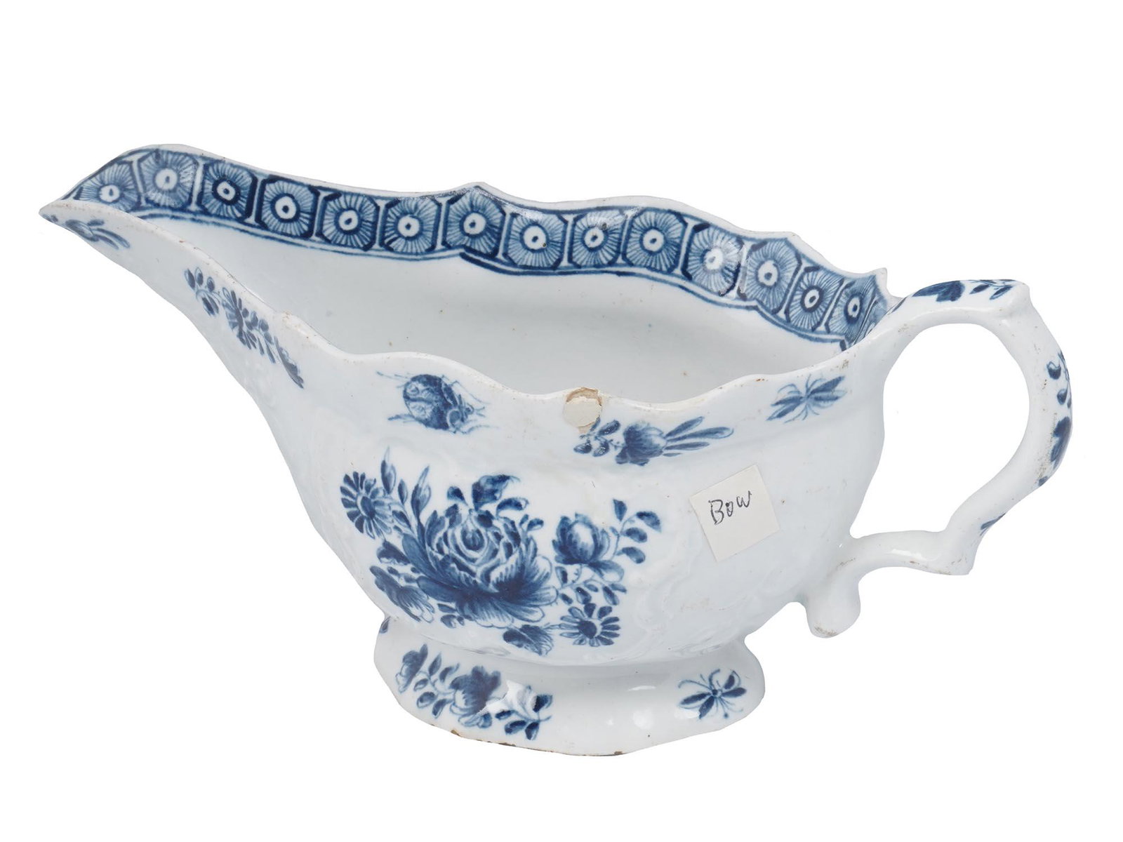 ANTIQUE BRITISH BLUE FLORAL PORCELAIN SAUCE BOAT: Antique 18th century British Blue Rose Floral porcelain bow sauce boat. A flat bottomed fluted body with scrolled handle. An interior and exterior are adorned with embossing and hand painted cabbage r