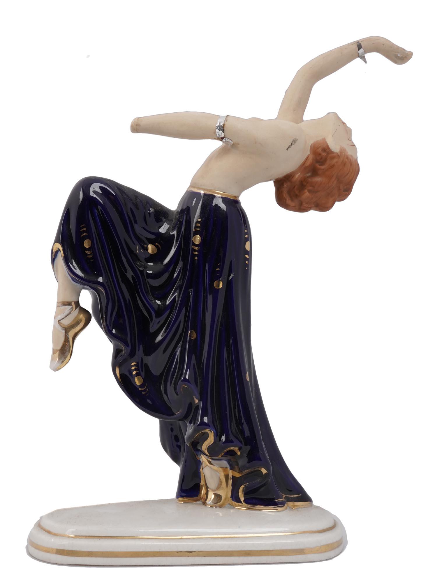 JAPAN ART DECO PORCELAIN MORIYAMA DANCER FIGURINE: A vintage Japanese Art Deco style Moriyama hand painted porcelain figurine on an oval gilded base. The figurine depicts a semi nude lady dancer with a cobalt blue and gilt skirt. Hallmarked with a man