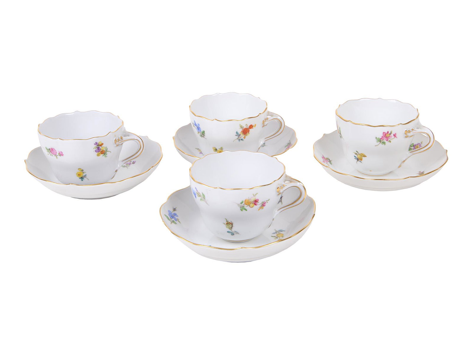 ANTIQUE MEISSEN PORCELAIN COFFEE CUPS AND SAUCERS: Four pairs of antique porcelain coffee cups and saucers manufactured by Meissen. The pieces are delicately painted with polychrome sprays of flowers and feature gilt rims and handles throughout. Marke