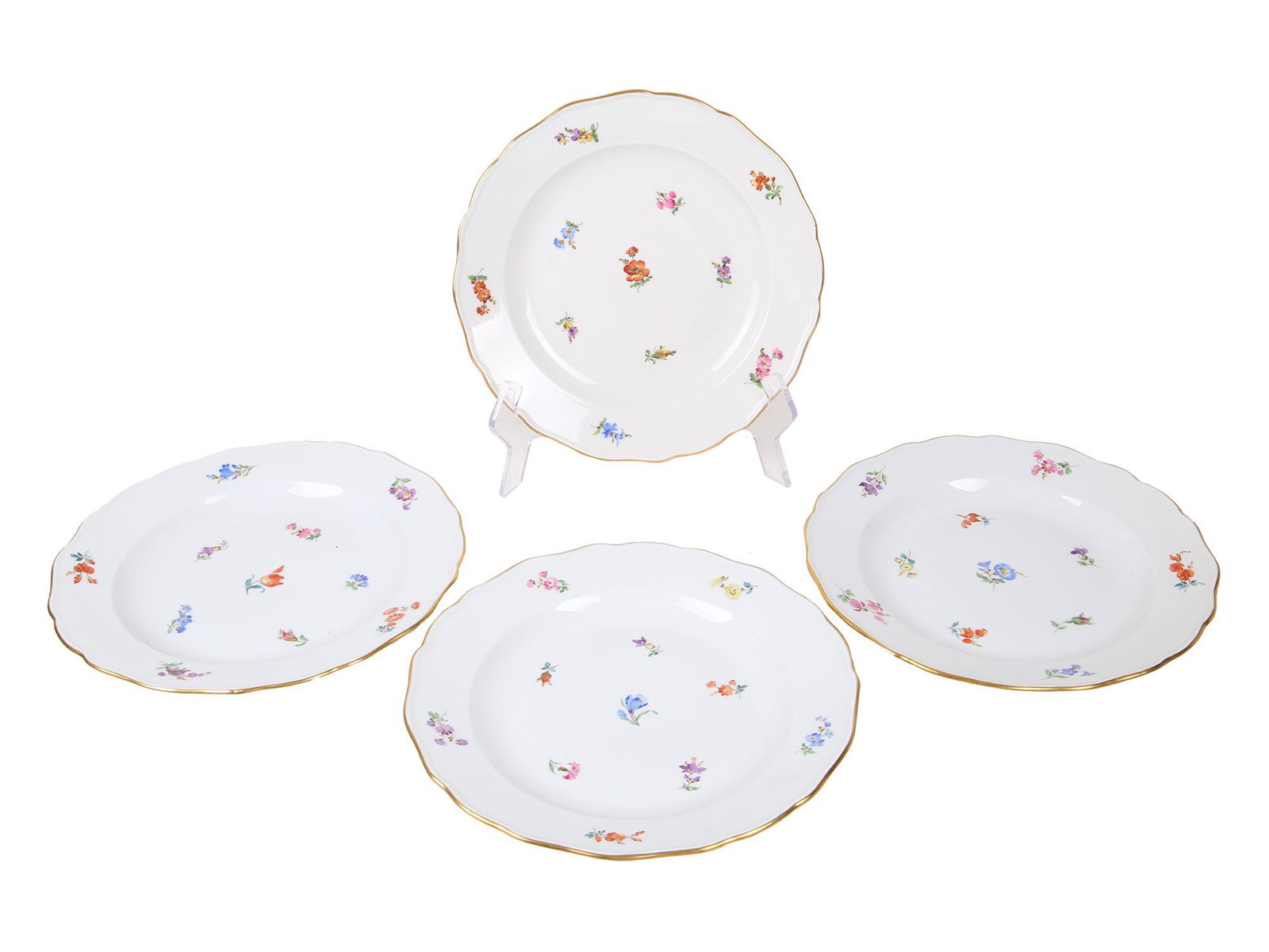 FOUR ANTIQUE 1900S MEISSEN PORCELAIN PLATES: Four antique porcelain dessert plates manufactured by Meissen. The pieces are delicately hand painted with polychrome sprays of flowers and feature gilt rims throughout. Marked to the underside with b