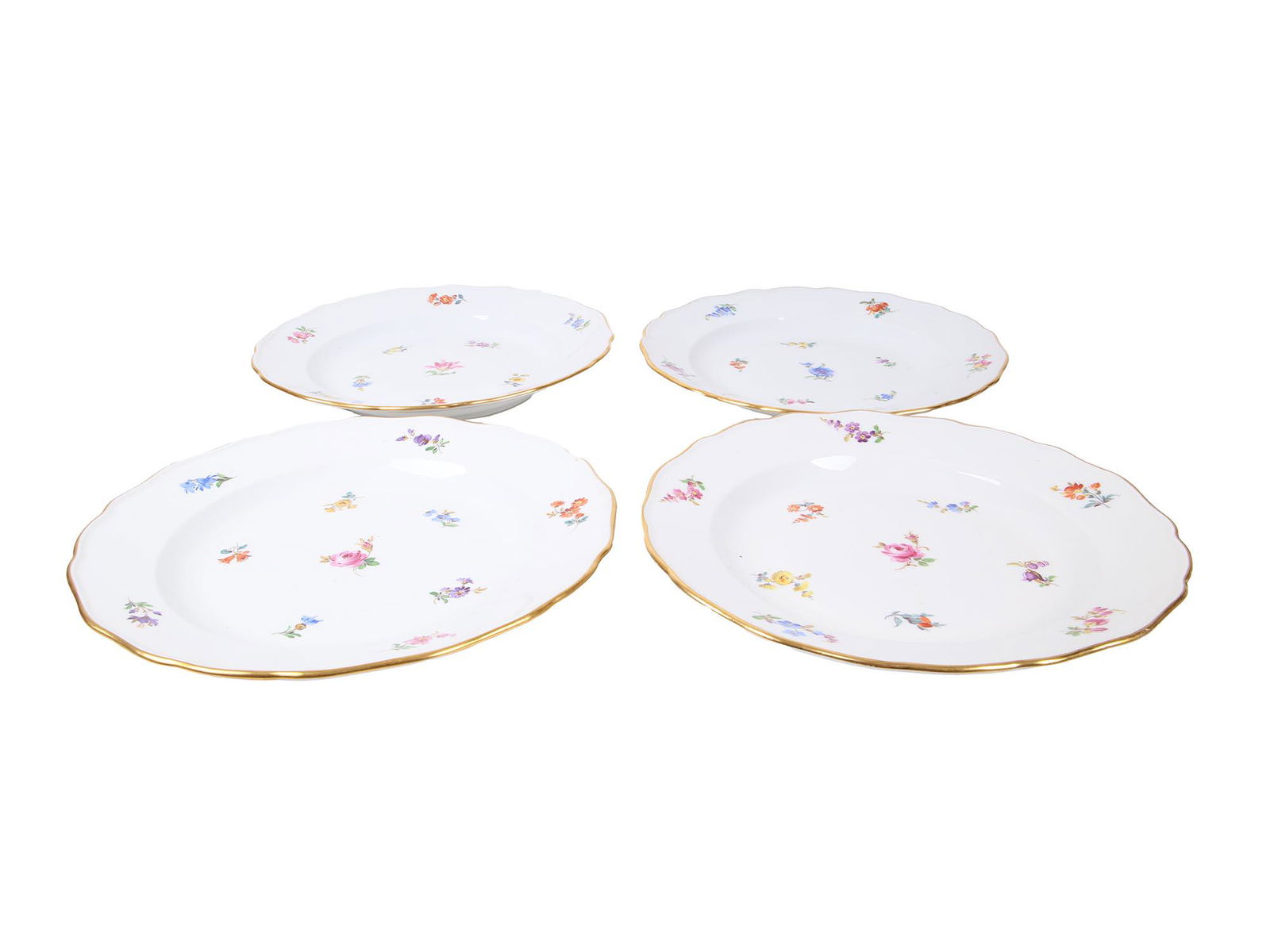 ANTIQUE MEISSEN PORCELAIN TEA CUPS AND SAUCERS: Four pairs of antique porcelain tea cups and saucers manufactured by Meissen. The pieces are delicately painted with polychrome sprays of flowers and feature gilt rims and handles throughout. Marked t
