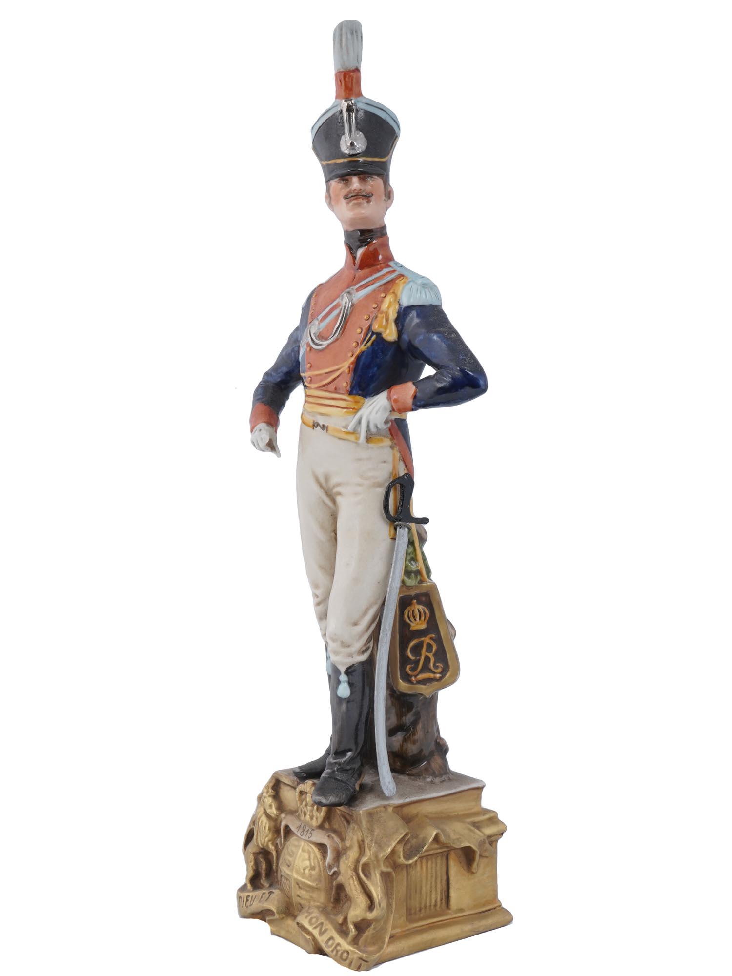 CAPODIMONTE PORCELAIN FIGURINE SOLDIER BY B MERLI: A vintage Italian Capodimonte porcelain figurine of an English Army Dragoon, a Soldier of the Napoleonic army 1815. Sculptured by Bruno Merli. Engraved with a motto, Dieu Et Mon Droit, God and My Righ