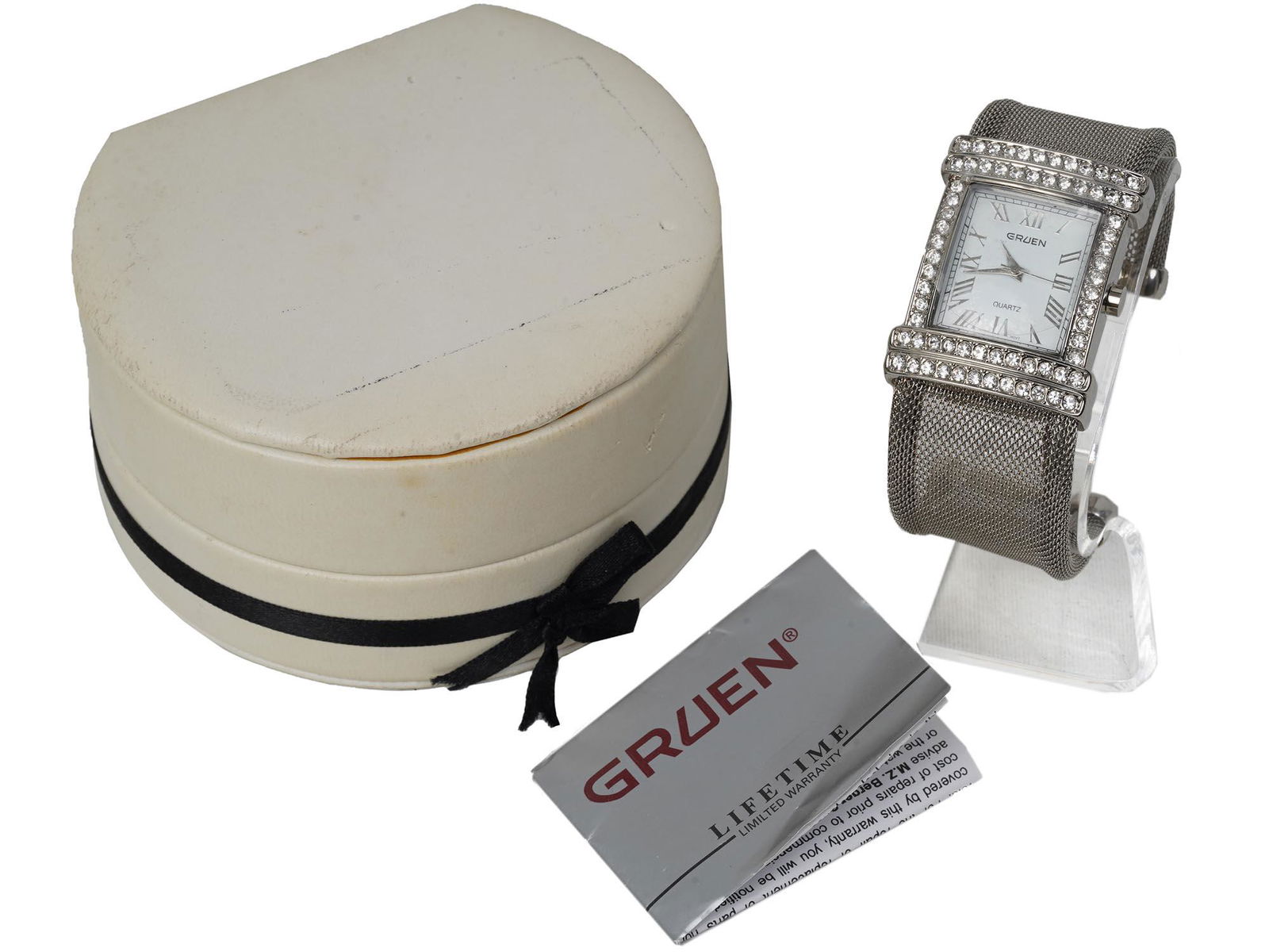 A VINTAGE GRUEN WOMEN'S BRACELET WATCH IN A BOX: A vintage rectangular women's Gruen bracelet watch decorated with rhinestones. Base metal bezel, Japan movement, stainless steel back as marked on verso. Model no. GR10021. Decorated with gemstones on