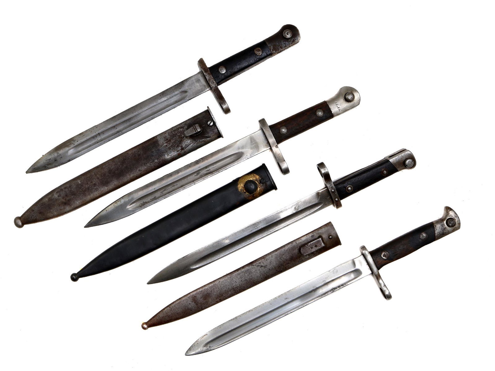 A LOT OF FOUR MANLICHER AND MAUSER BAYONETS: 1st and 2nd - A Turkish M1935 Mauser bayonets with scabbards;3rd - Austro-Hungarian M1895 Manlicher Rifle bayonet with scabbard;4th - A Spanish M1893 Mauser bayonet without scabbard. Dimensions: L: 15