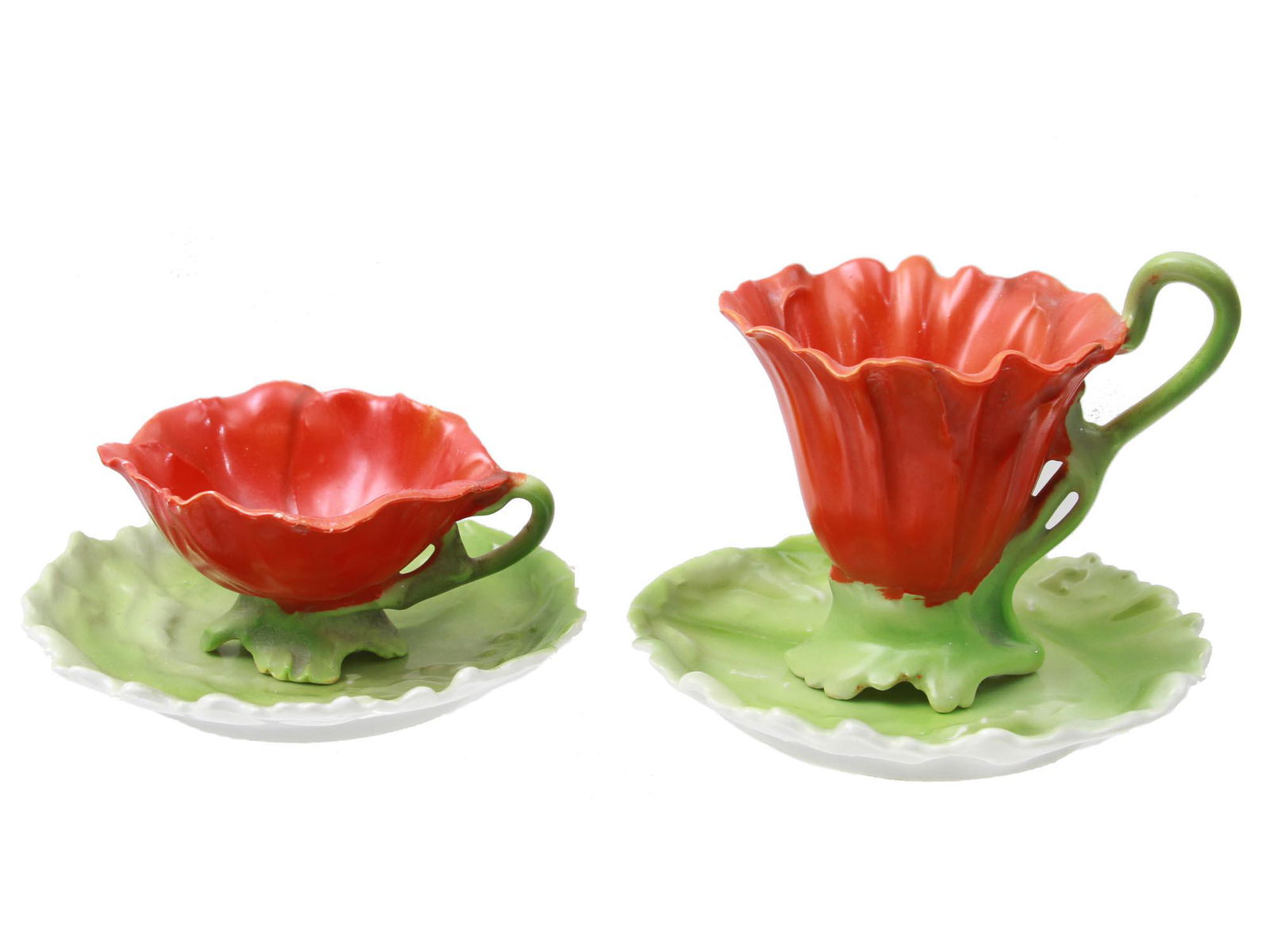 A PAIR OF ROYAL BAYREUTH PORCELAIN POPPY TEA CUPS: A pair of Bavarian Royal Bayreuth porcelain teacups with saucers in two various sizes in the form of red poppies with green leaves. Marked with blue manufacturer's stamps on the bottom. Circa: the ear