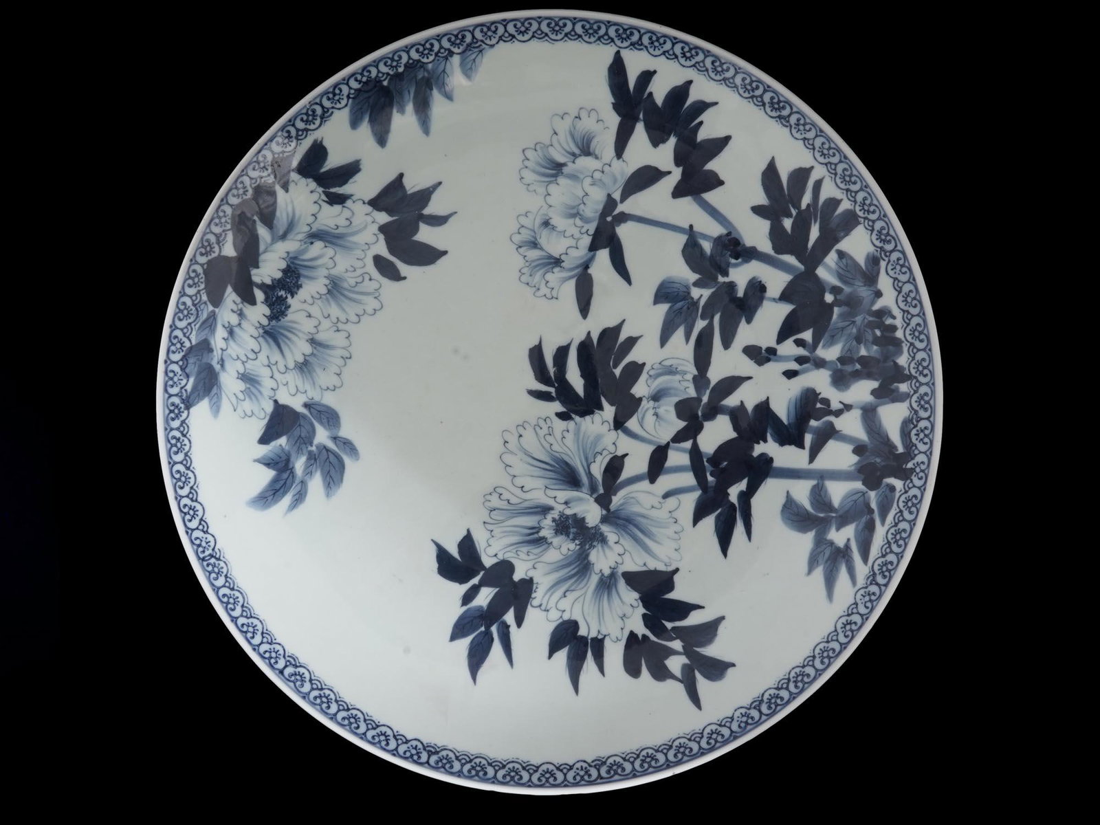 BLUE AND WHITE CHINESE PORCELAIN CHARGER PLATE: An antique Chinese white porcelain plate hand painted with fine cobalt blue peony design, Qing dynasty, 1644â€“1911. Blue four-character mark on the bottom. Chinese Porcelain Tableware And Servew