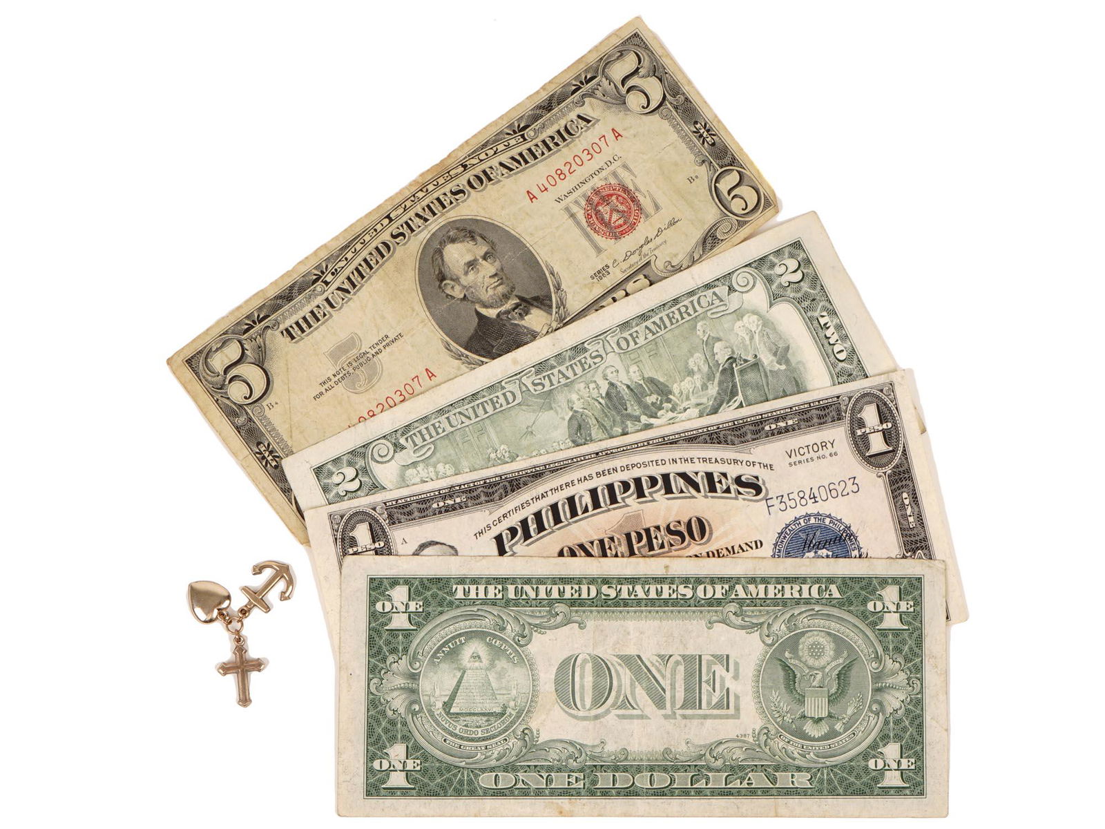 VINTAGE BANKNOTE COLLECTION GOLD PLATED PENDANT: A collection of four vintage paper banknotes including a 1935-C United States one dollar bill, a 1963 United States five dollar bill, a 1995 red seal two dollar bill, and a Philippine Victory series o