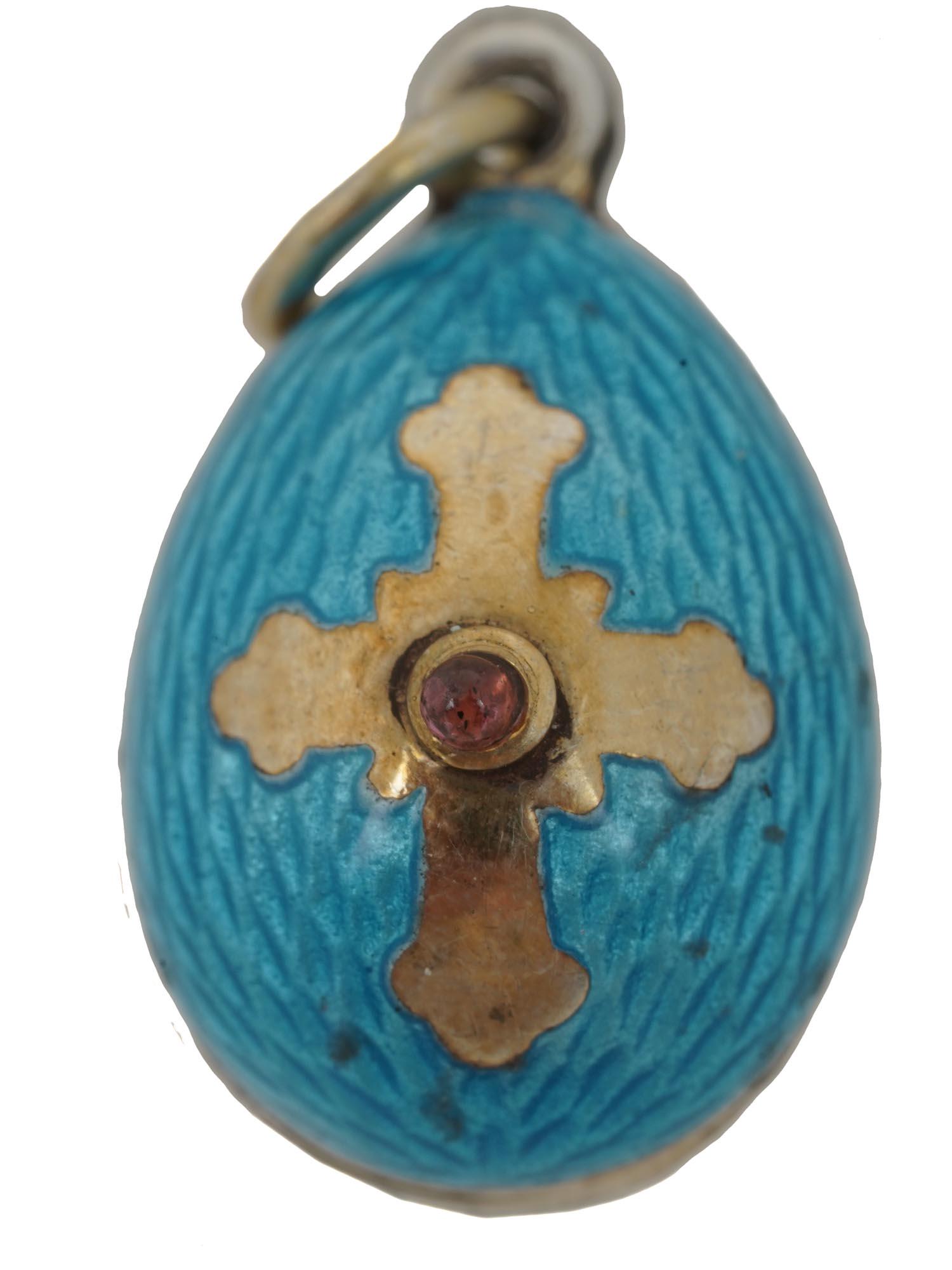 RUSSIAN GILT SILVER AND ENAMEL CROSS EGG PENDANT: Russian gilt silver egg pendant covered with blue-violet guilloche enamel and decorated with a cross on the obverse and a pink cabochon in the center. Hallmarks on the loop: 84 silver standard, master