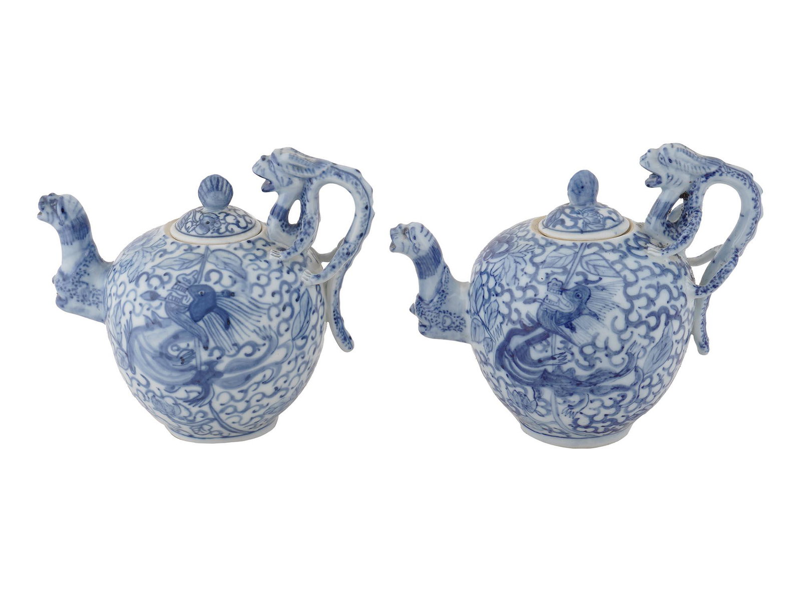 TWO ANTIQUE CHINESE DRAGON PORCELAIN TEAPOTS: Two antique Chinese blue and white lidded teapots featuring hand painted dragon images. Handles and spouts are manufactured as dragons with open mouths. Marked with a six character Yongzheng mark (cir