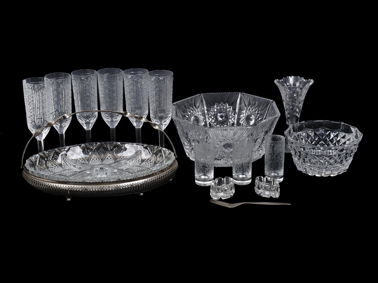 VINTAGE CRYSTAL CUT GLASS SERVEWARE COLLECTION: A collection of crystal cut glass tableware pieces including two richly decorated bowls, two ashtrays, six champagne glasses with snowflake design throughout, one footed wine glass, a serving dish set