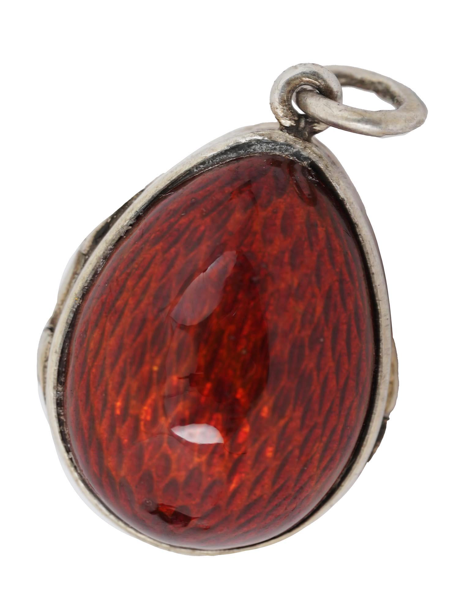 RUSSIAN 88 SILVER END GUILLOCHE ENAMEL EGG LOCKET: A fine Russian egg locket made of silver and covered with a shimmering red guilloche enamel. Opening to reveal an empty place for storage of memorabilia. Marked on the fitting ring with the maker's in