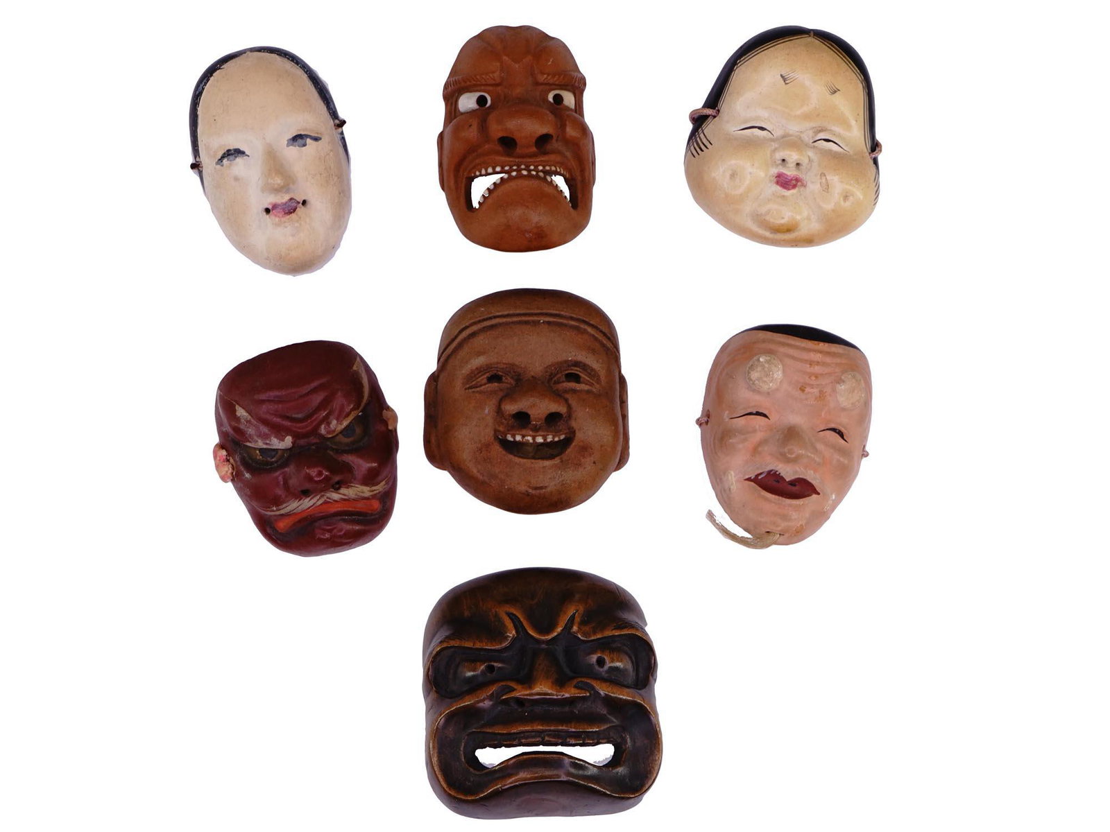 ANTIQUE JAPANESE NETSUKE WOOD CERAMIC NOH MASKS: A group of antique Japanese Noh Theatre Netsuke hand craved and hand painted wooden and ceramic masks. The masks depict various grimaces. Marked, Made in Japan, on the back. Strings on the back. Noh i