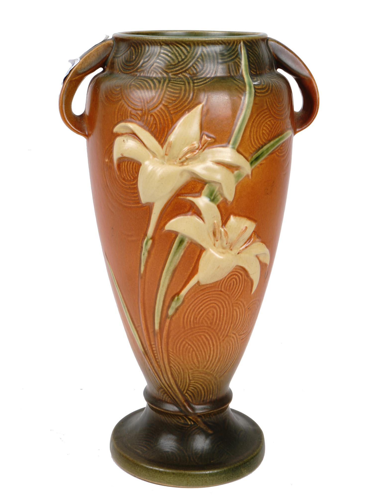 LARGE ROSEVILLE ZEPHYR LILIES BROWN POTTERY VASE: A large Roseville amphora shaped brown and green pottery vase with a pair of handles. The exterior of the vase is adorned with a hand crafted Zephyr Lilies design and engraved in a swirl pattern groun