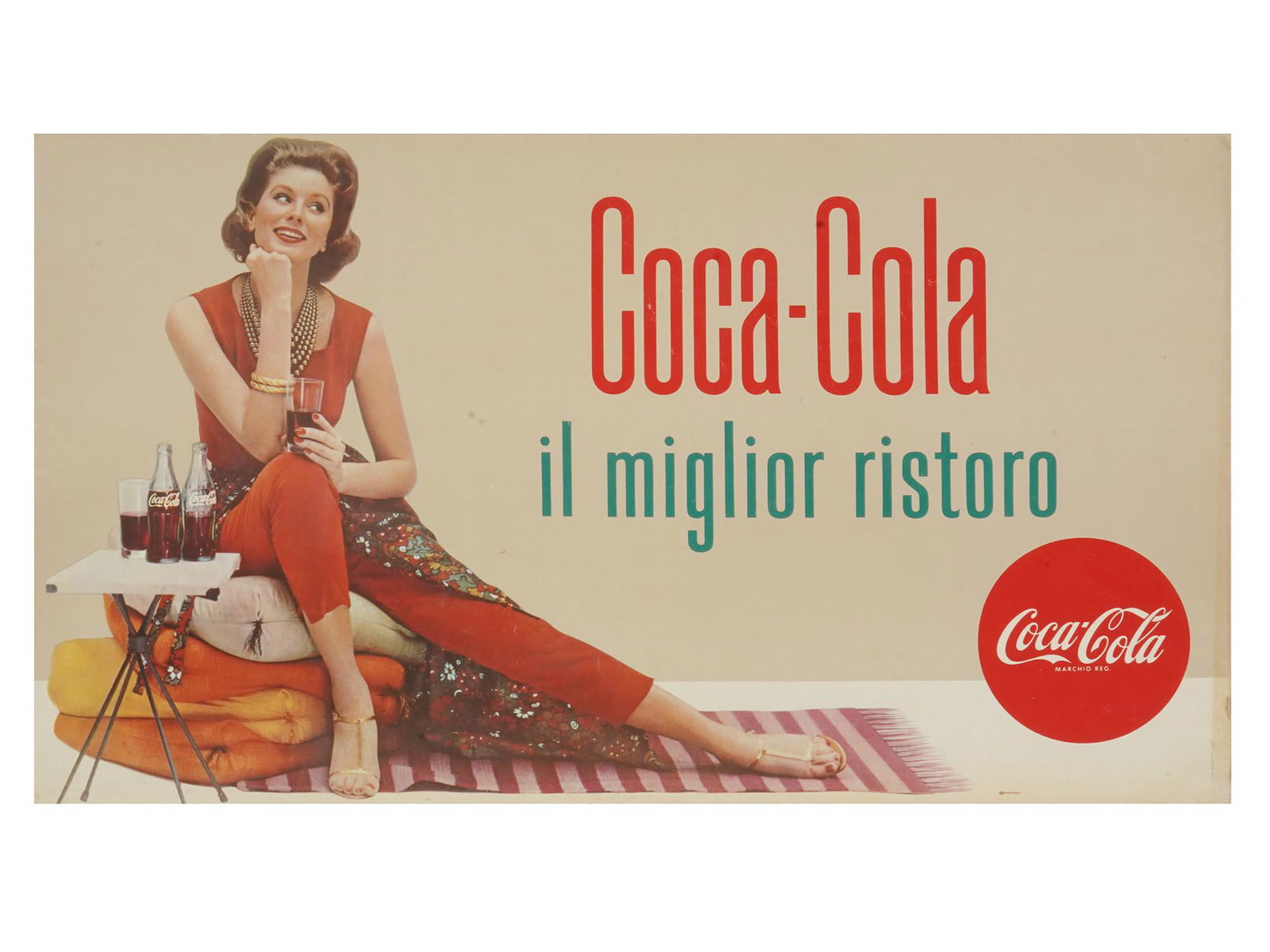 VINTAGE COCA COLA ITALIAN PIN UP ADVERTISING POSTER: A Mid century Italian Coca Cola advertising lithographic poster printed on a cardboard. The poster depicts a portrait of a young woman sitting and holding a glass of coke. Titled in Italian in the pri