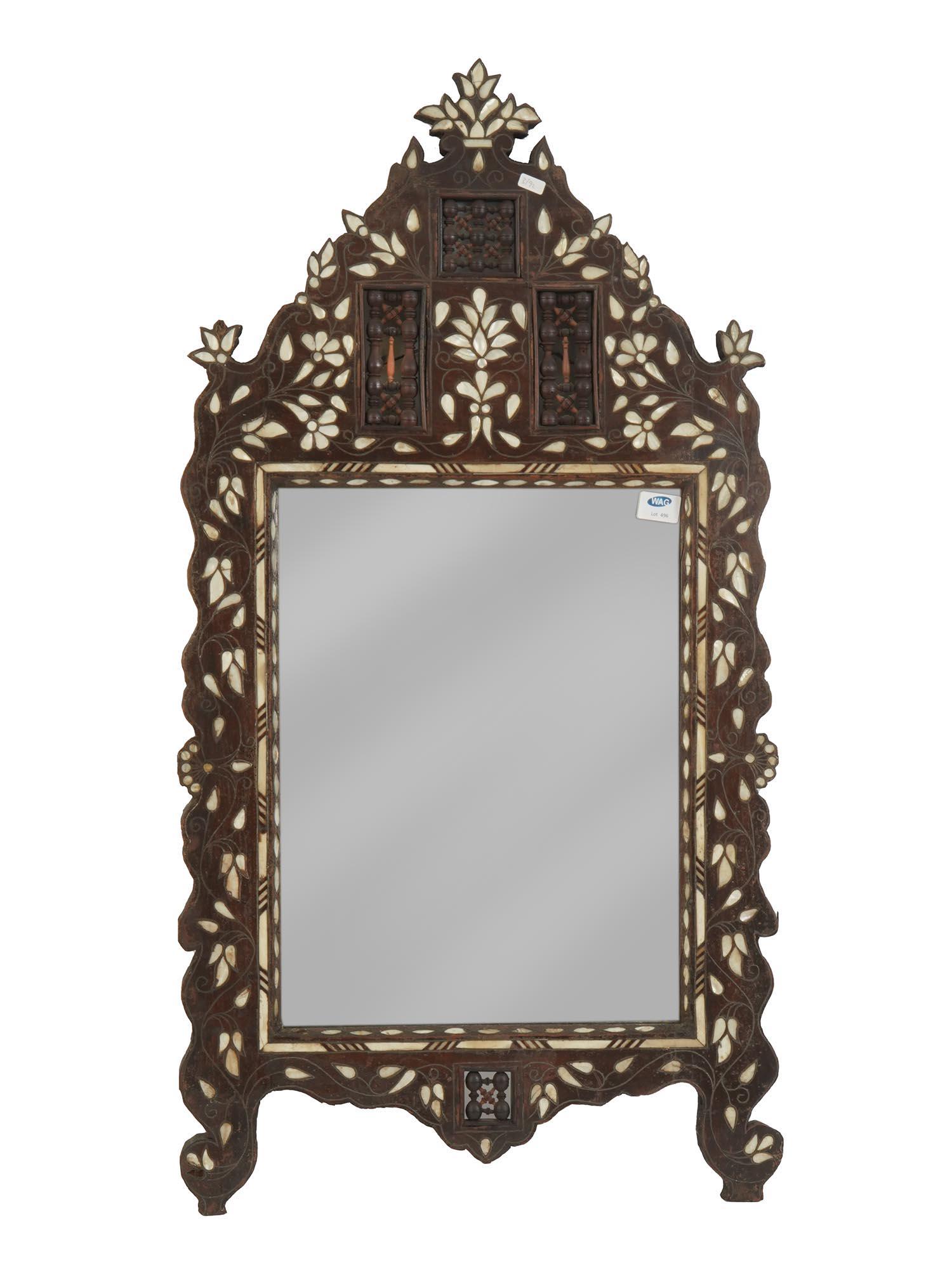 MOROCCAN WOOD INLAID WITH MOTHER OF PEARL MIRROR: Antique Moroccan hand crafted wooden mirror. The mirror is adorned and inlaid with mother of pearl foliage and floral patterns. The mirror is decorated with openwork accents on the upper and lower par