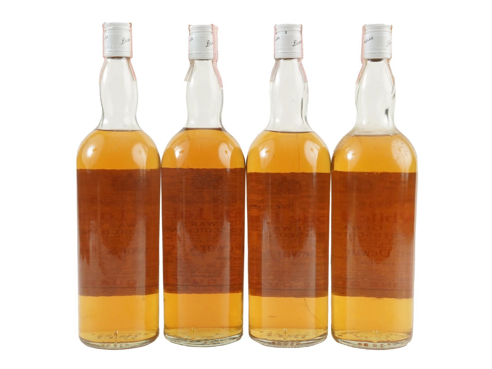 SEALED WHITE LABEL WHISKEY BOTTLES, CIRCA 1960S: Four vintage sealed alcohol bottles of White Label Dewars Blended Scotch Whiskey, product of Scotland. Circa 1960s. A distillery in the Scottish Highlands known for its pronounced flavors of honey, sp