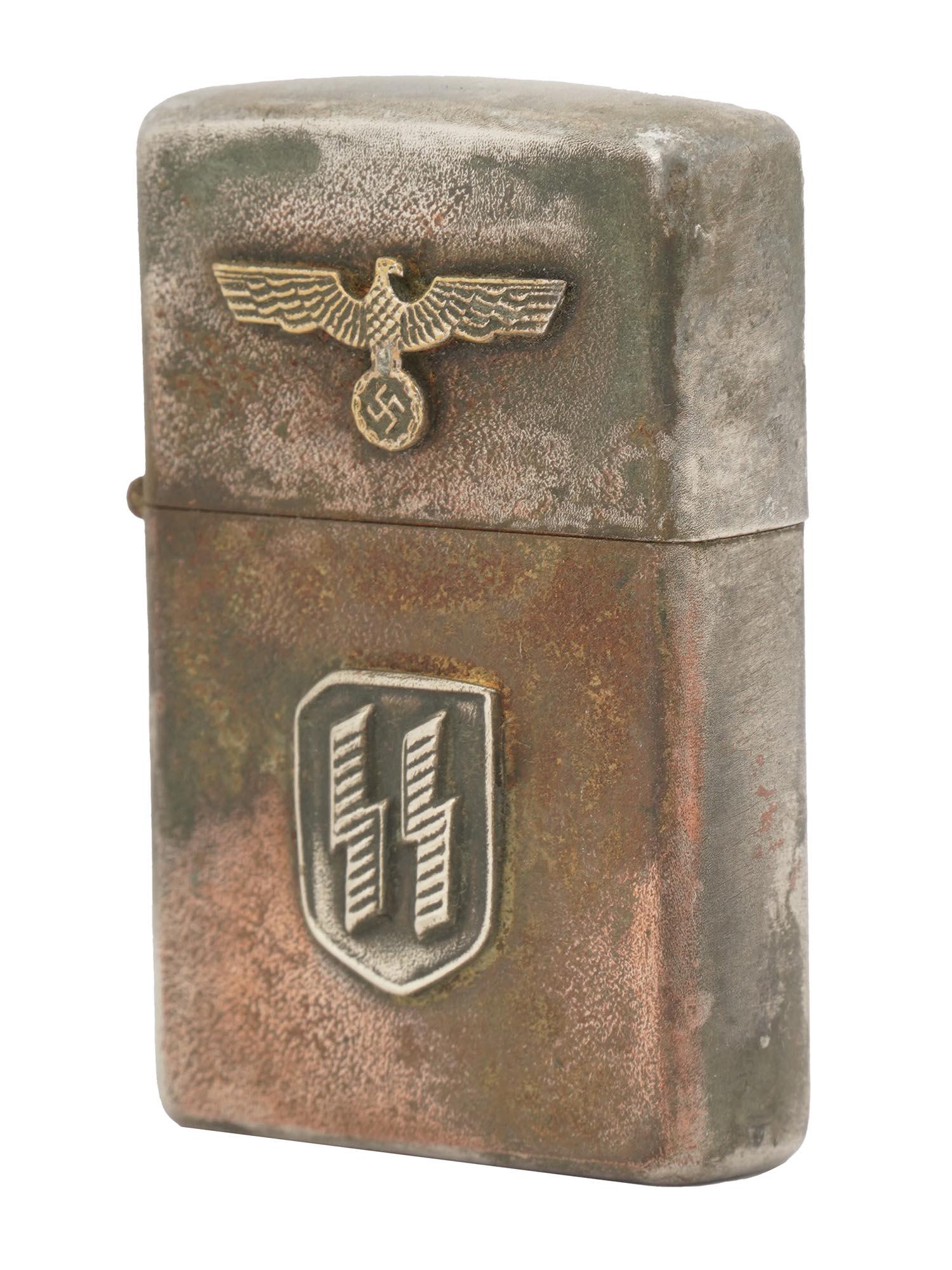 NAZI GERMAN WWII WAFFEN SS CIGARETTE LIGHTER: A Nazi German WWII Waffen SS cigarette lighter in the style of Zippo. Decorated with an affixed national eagle clutching a swastika on the top and an SS rune insignia lower to the center on the body.