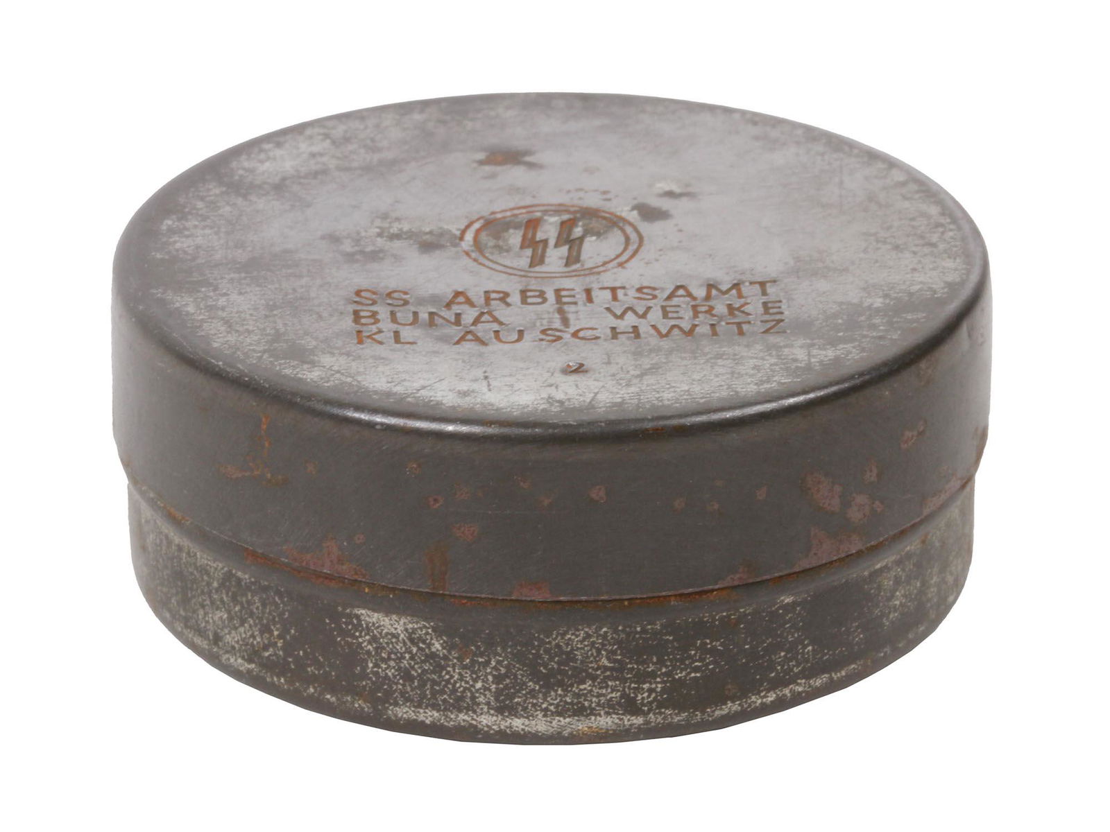 WWII GERMAN THIRD REICH AUSCHWITZ SS PILL BOX: A round metal WWII German Third Reich Auschwitz SS Pill Box. Stamped on the lid with an SS emblem and inscribed in German: Arbeitsamt Buna Werke KL Auschwitz. Auschwitz concentration camp was a comple