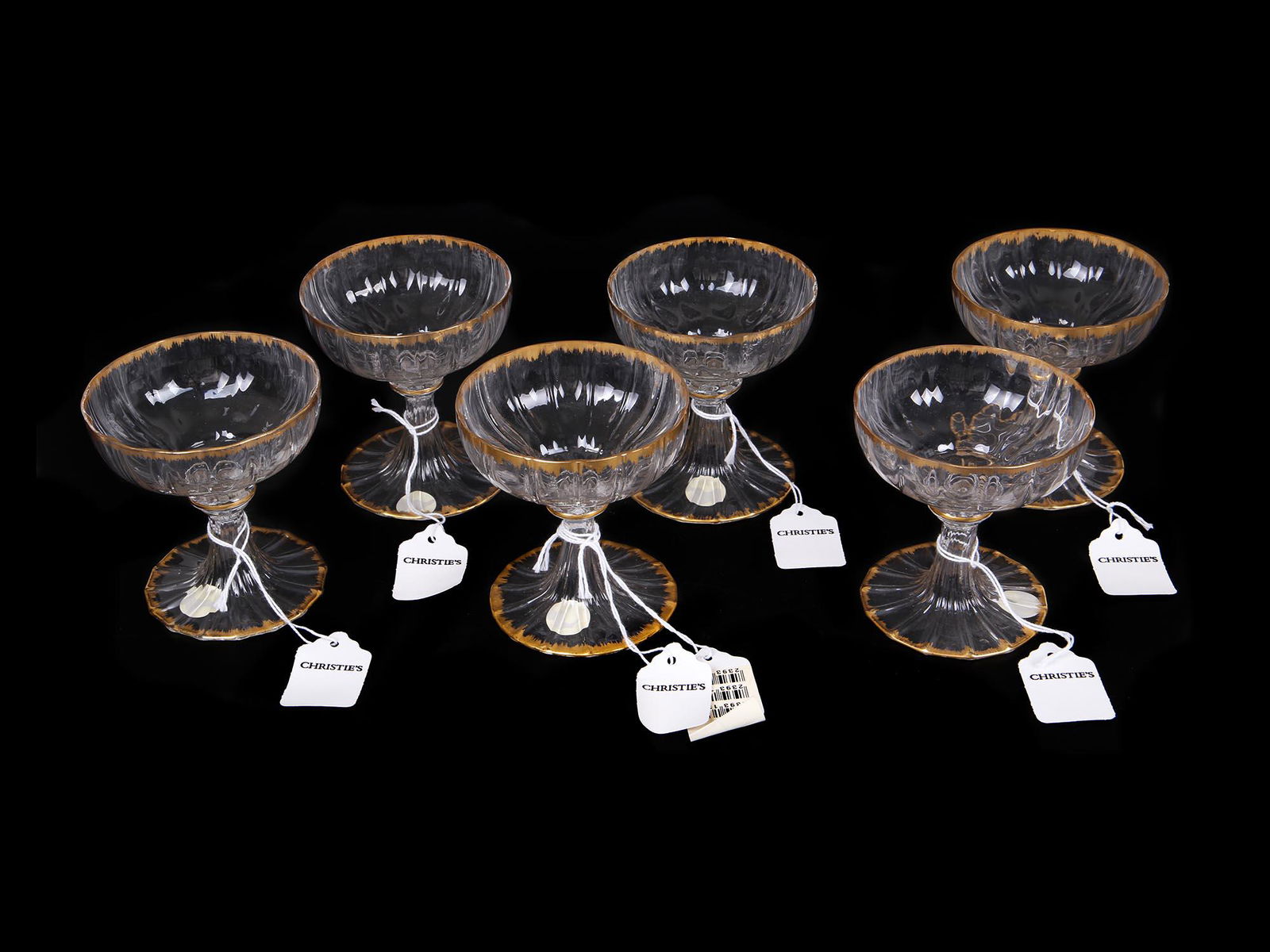 VENETIAN PARCEL GILT DECORATED CHAMPAGNE GOBLETS: A set of six vintage Venetian parcel gilt decorated champagne goblets. Circa the 20th century. One glass has a small crack. Collectible glassware and drinkware. Provenance: Christie's Auction, October