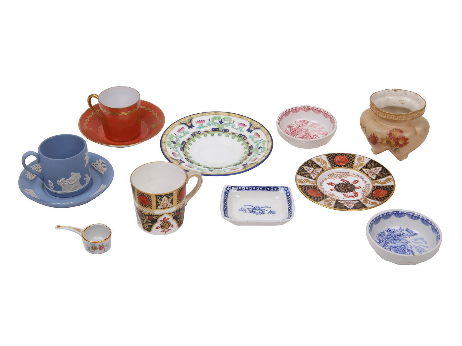 GROUP OF TWELVE PORCELAIN TEA CUPS SAUCERS BOWLS: A collection of twelve porcelain tea cups, saucers, trays, small bowls, miniature souvenir items, and others. A pair of small blue and white and red and white bowls are marked, Wods Burslem England Se