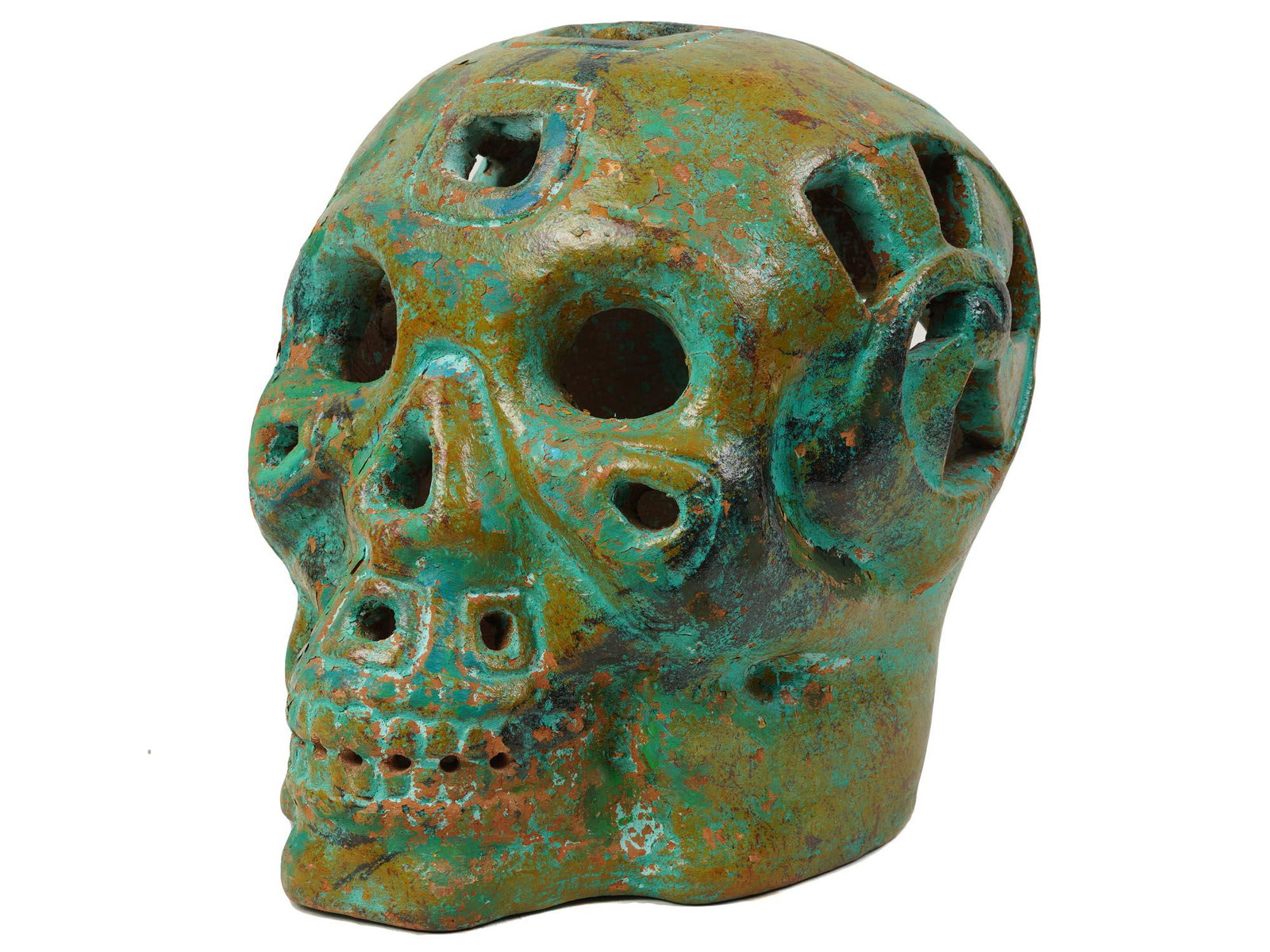 AN INDONESIAN CERAMIC GREEN FIGURINE OF SKULL: An Indonesian ceramic green amulet figurine in the shape of a skull with ornate and hole accents. Unmarked. Vintage male home decor and collectibles. Dimensions: Height 30"inAll measurements are appro