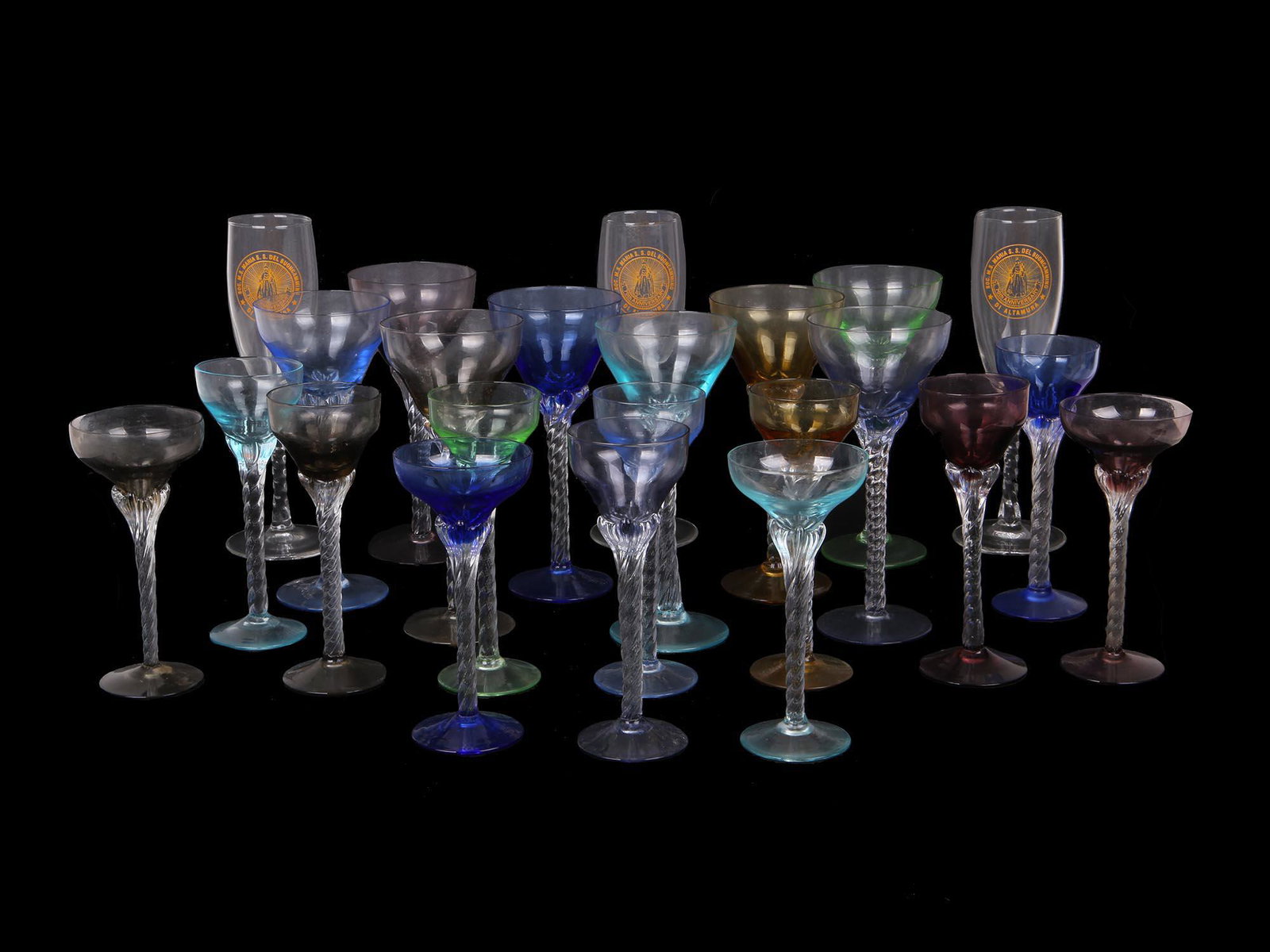 MID CENTURY HAND BLOWN TABLEWARE GLASSES, BLEFELD: A large collection of vintage multi colored hand blown cordial and champaign glasses most likely made by Blefeld circa 1960, and three fluted champaign glasses bearing the emblem of the Societa M.S. M