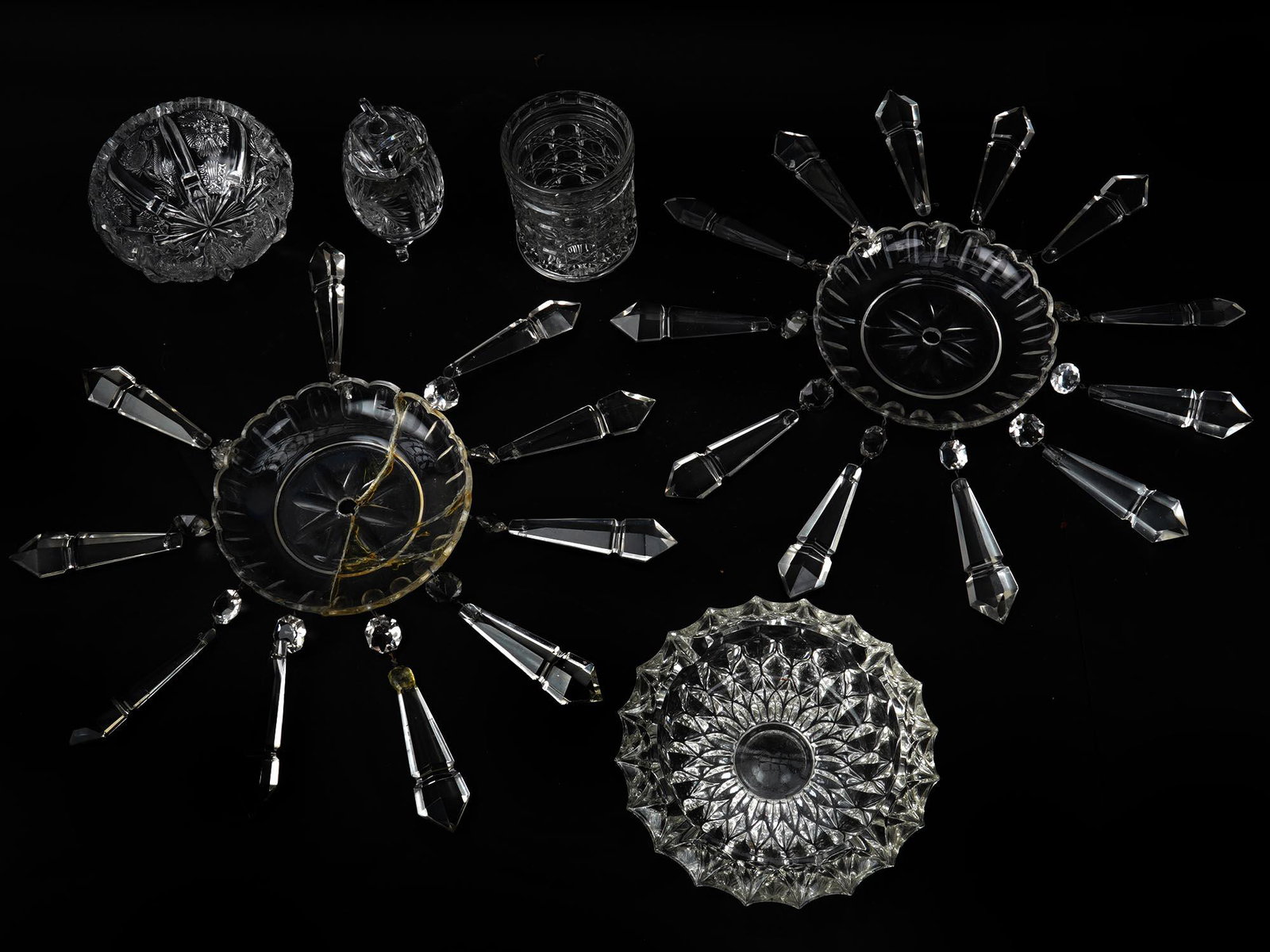 A SMALL COLLECTION OF SIX CRYSTAL CUT GLASS WARE: A small collection of six pieces of clear crystal cut glass ware. The collection includes a pair of bobeches for candle holders adorned with long clear faceted spear prisms, a glass ashtray, a small n