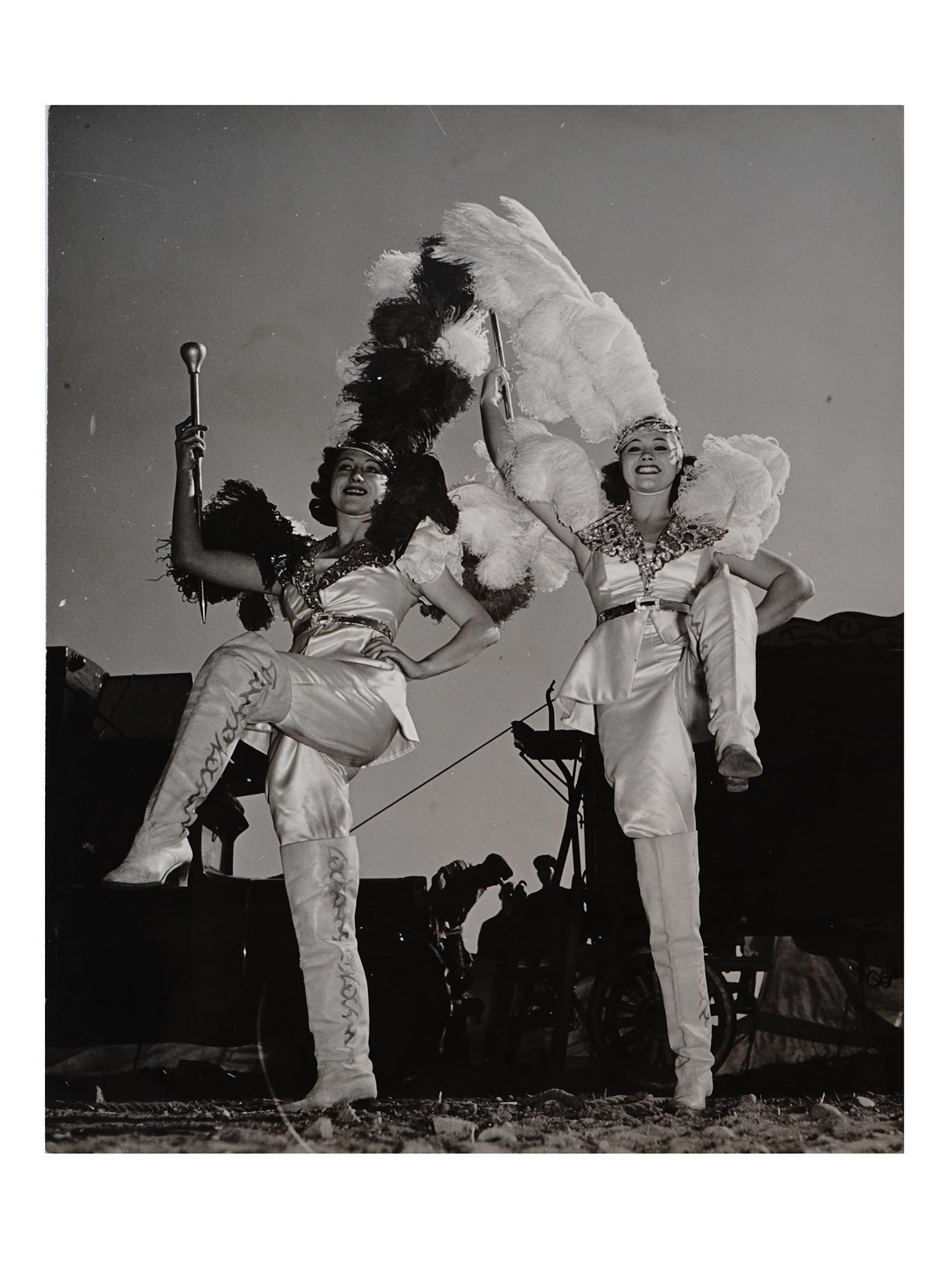 1940S AMERICAN PHOTOGRAPH BY NATHANIEL FIELD: A mid century black and white photo print depicting two female circus dancers. Signed by the artist on the backside and features a paper label with professional information about the photo. Nathaniel 