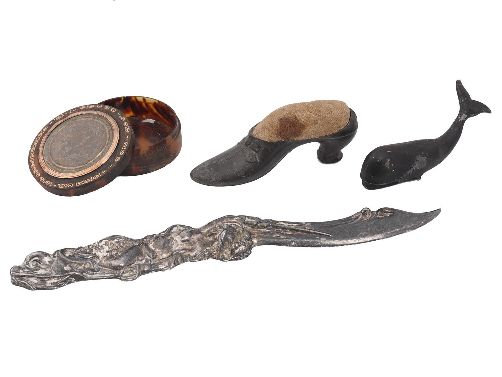 FOUR ANTIQUE LATE 19TH CENTURY HOME DECOR ITEMS: Four antique late 19th century items including a needlework tool in the form of a shoe for keeping needles, a cast iron figurine of a whale, an iron knife with a one side blade and a cast hilt depicti