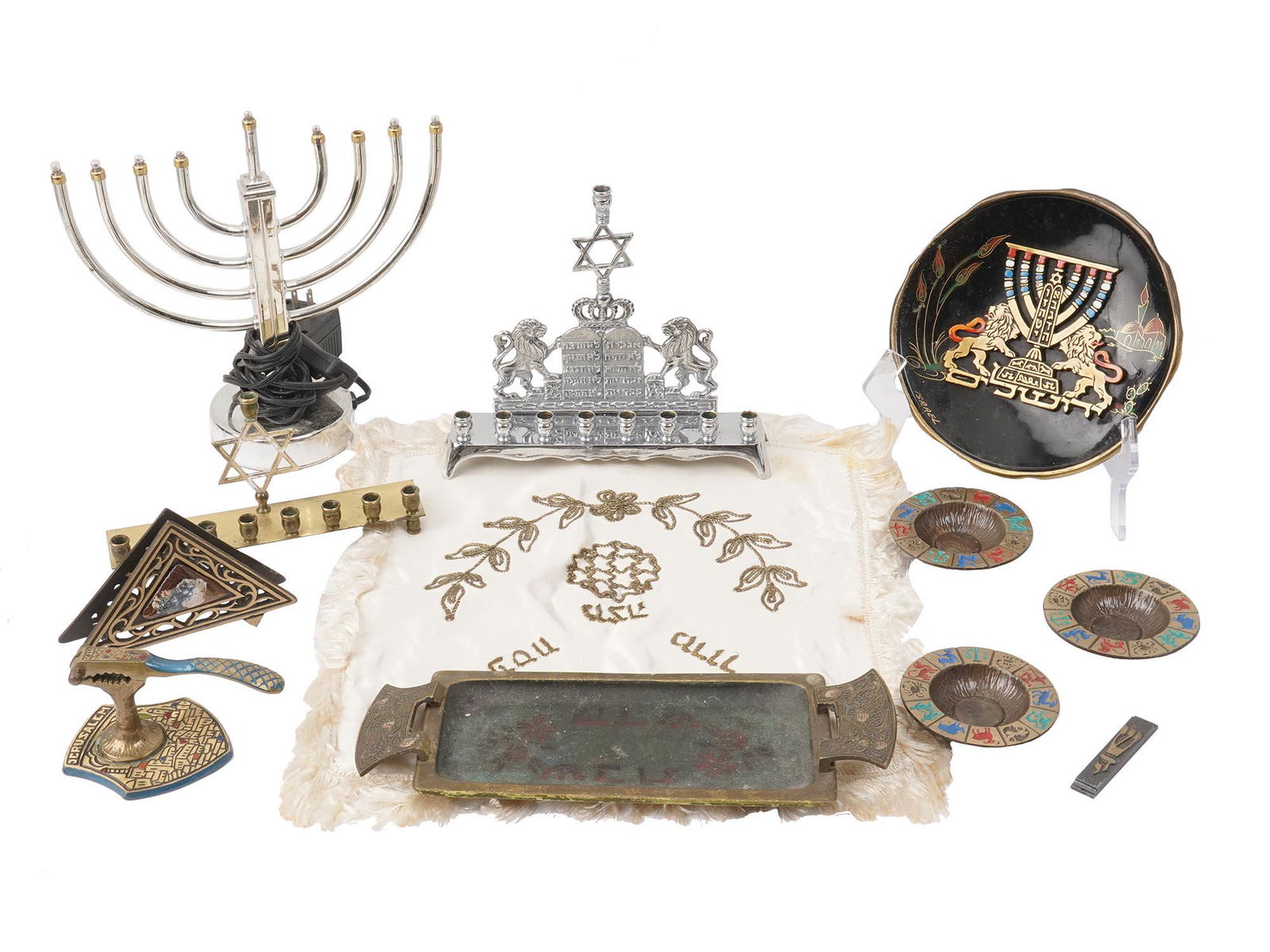 MID CENTURY ISRAEL JUDAICA ACCESSORIES AND DECOR: The lot includes a vintage judaica Challah bread cover decorated with fringe and gold tone embroidery; an antique Shabbat meal Challah brass bread tray, circa 1950; a set of three brass and color enam
