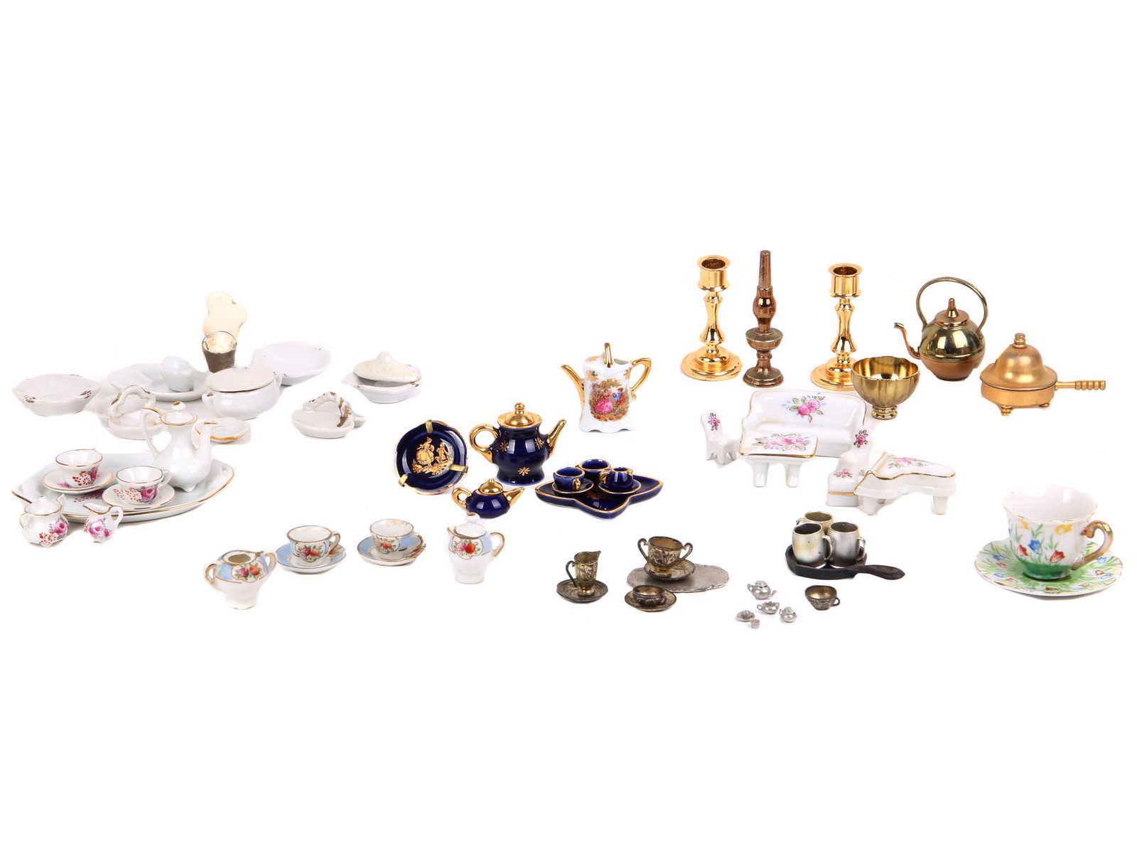 A LARGE LOT OF MINIATURE DOLLHOUSE TABLEWARES: A large collection of miniature metal and porcelain dollhouse items including tea and coffee sets, tableware and kitchenware, miniature candleholders, a kerosene lamp, a set of furniture items, and mo