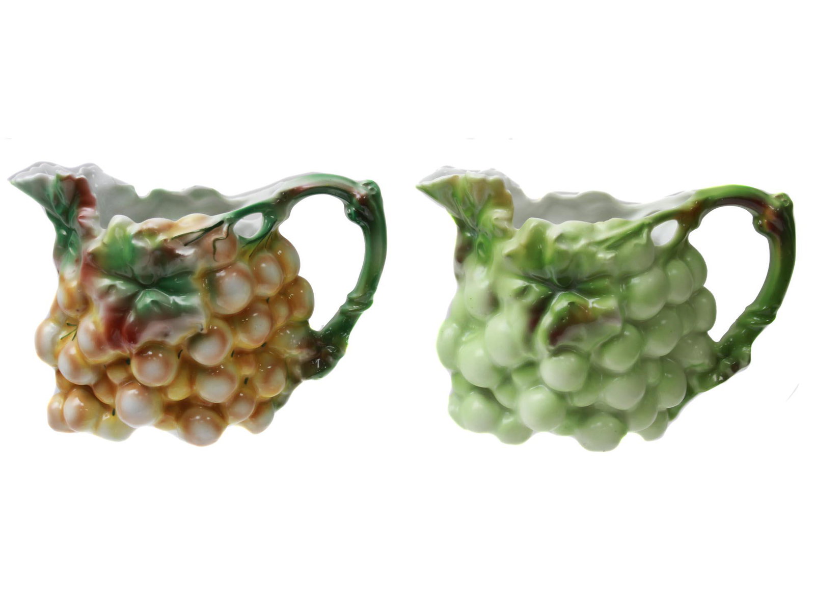 A ROYAL BAYREUTH GRAPE CLUSTER MILK PITCHERS: Two vintage porcelain milk pitchers modeled as grape clusters. A yellow grape pitcher marked on the bottom: Bavaria; a light green grape creamer marked: Germany. Dimensions: H: 4 1/2 in. Each.