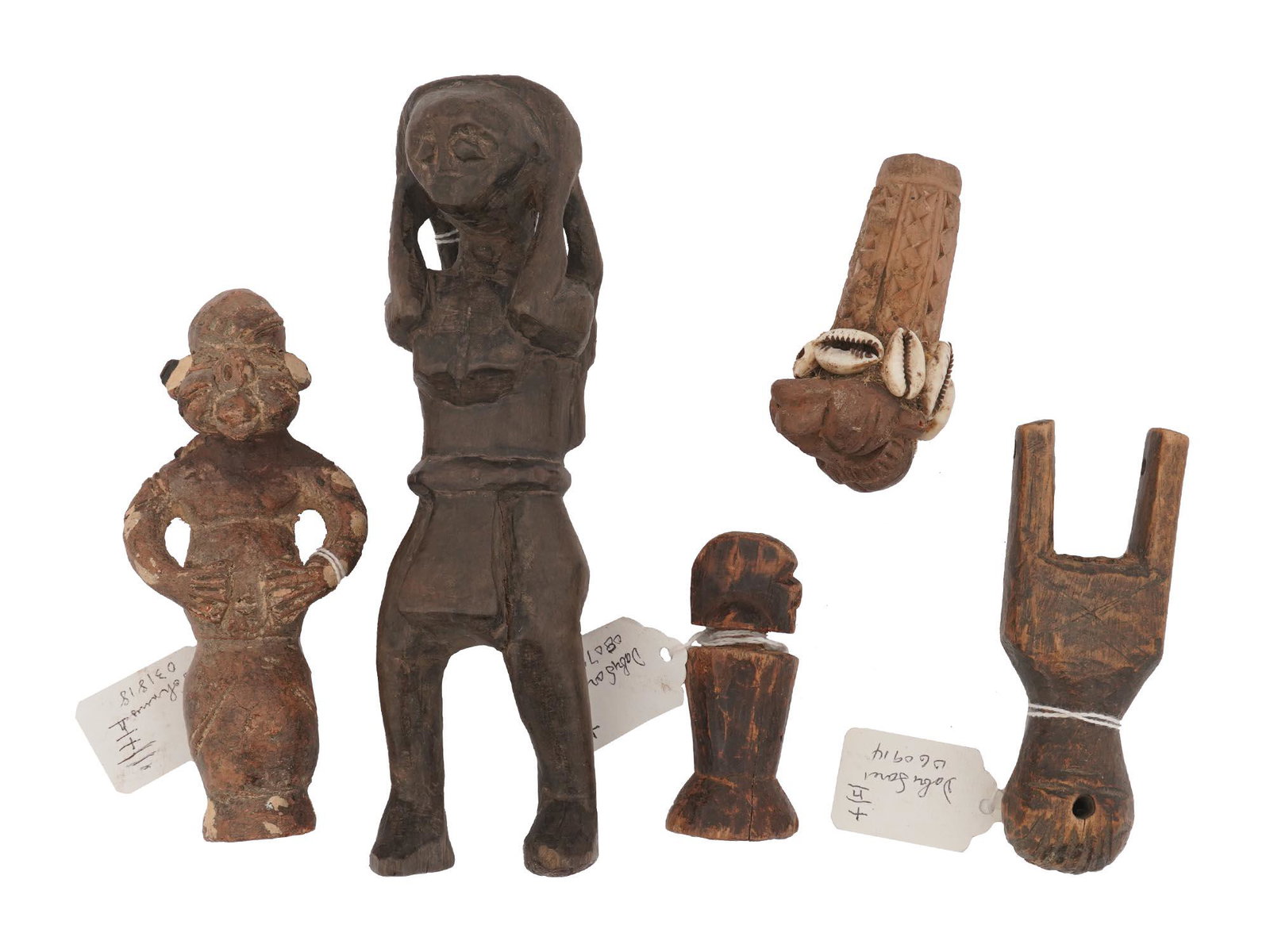 AFRICAN CARVED WOOD AND TERRACOTTA IDOL FIGURINES: A lot of five African hand-carved wooden and terracotta figurines representing human figures or idols. One of the figurines is decorated with sea shells. Pieces from Cameroon, Maconde region in Tanzan