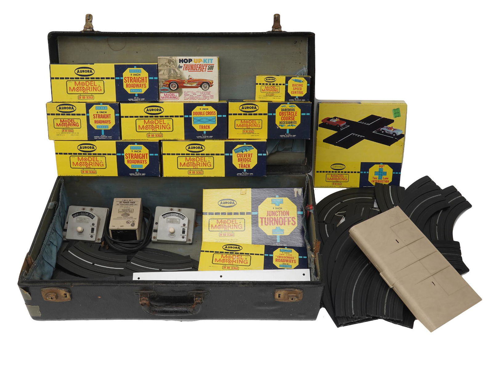 VINTAGE ELECTRIC AURORA MODEL MOTORING RACE SET: A vintage Aurora Model Motoring race set including straight roadways, a culvert bridge with track, a double cross track, an obstacle course, a racing speed control, junction turnoffs, a two line inter
