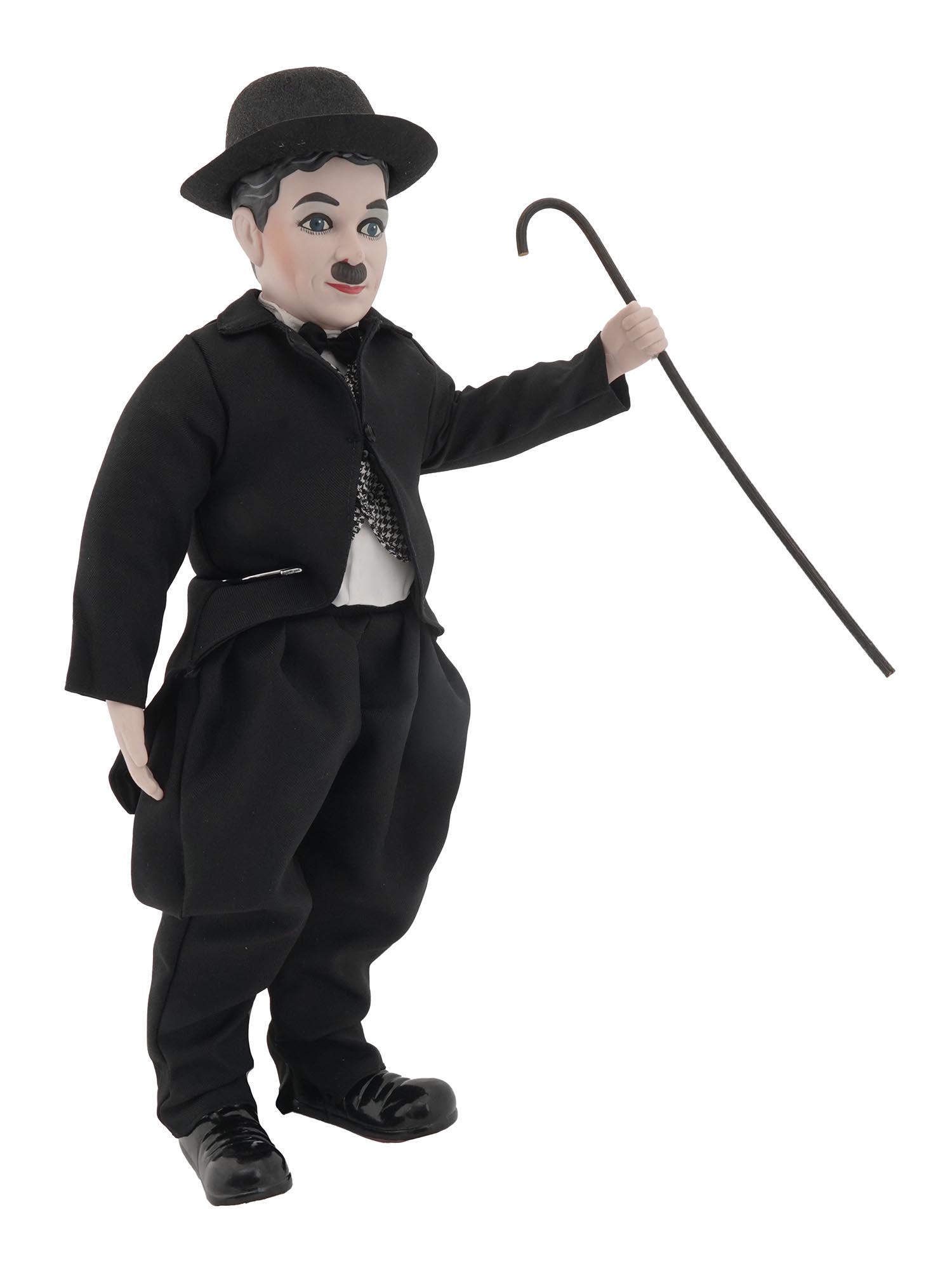 ENESCO CHARLIE CHAPLIN MUSICAL DOLL W STAND IOB: A vintage Charile Chaplin musical porcelain doll. The actor is represented as his most famous character, the Little Tramp. The doll plays The Entertainer tune. Production of Enesco, an American giftwa