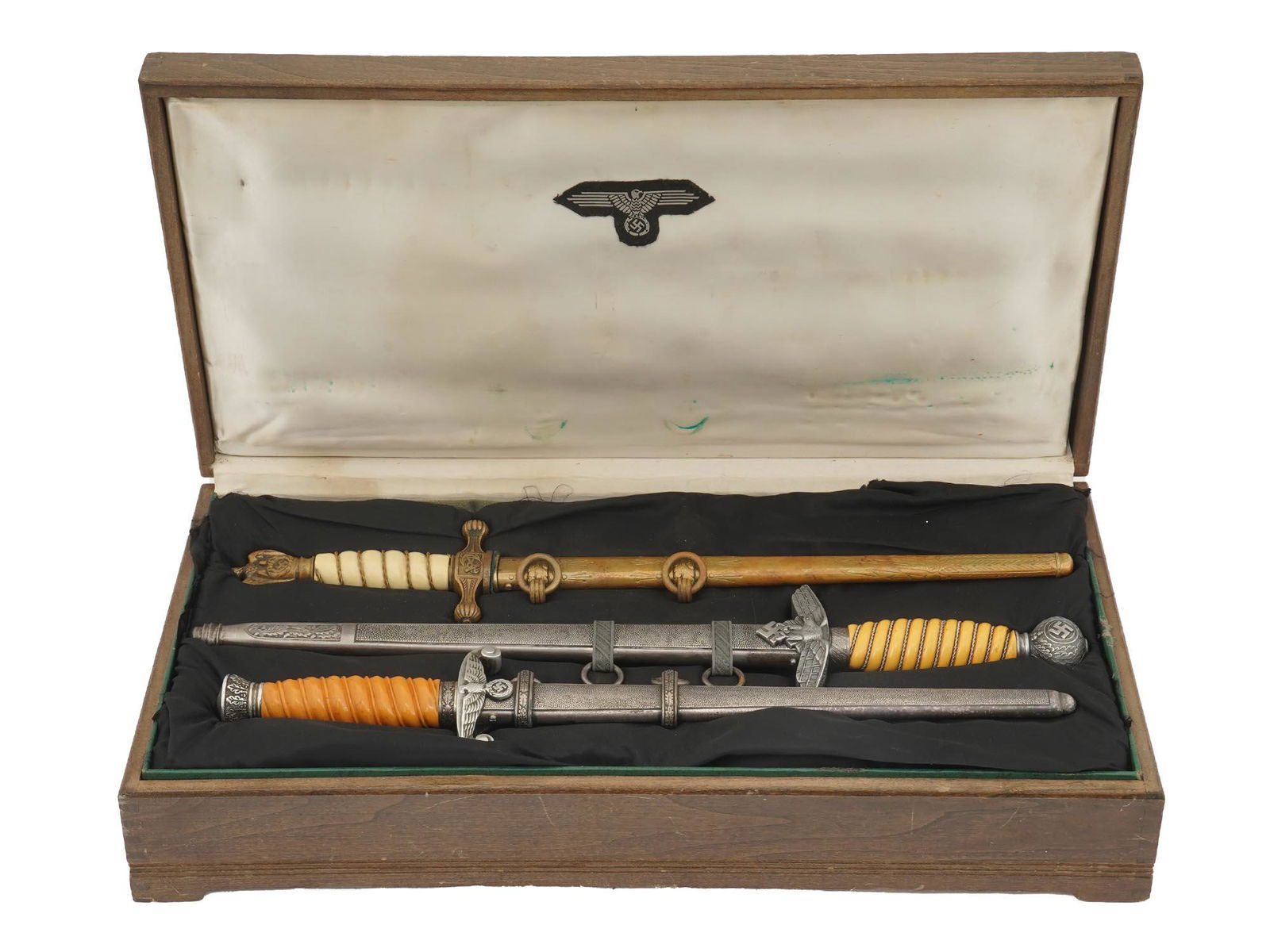 WWII NAZI GERMAN DAGGERS WITH SCABBARDS IN BOX: Three WWII German Army uniform daggers, each decorated with a Nazi-style German imperial eagle with a swastika. Includes a 1938 Kreigsmarine dagger, a 1937 Luftwaffe dagger manufactured by Lauterjung
